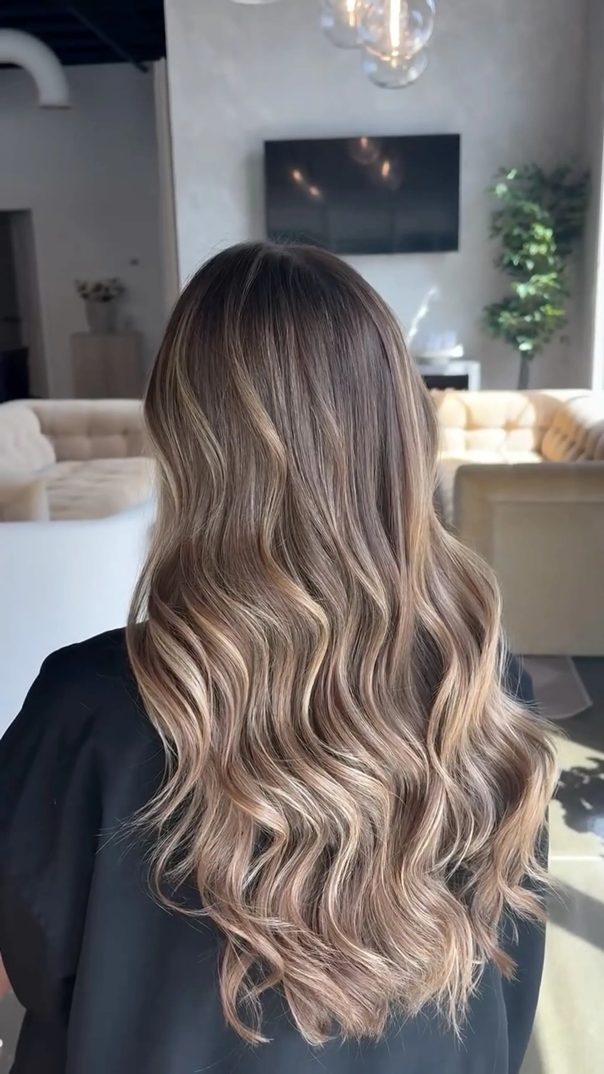 Long lived-in bronde hair with seamless dimensional balayage highlights styled in soft, cascading waves. 1
