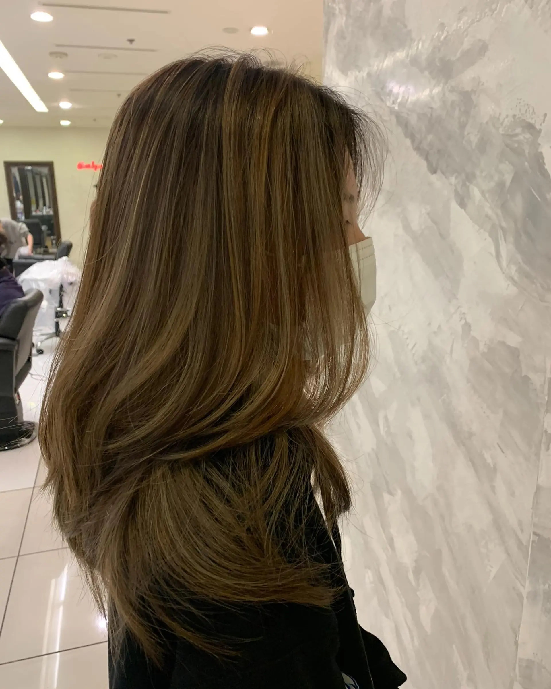 Long layered haircut featuring seamless ash brown balayage highlights with soft, face-framing layers and curved ends. 1