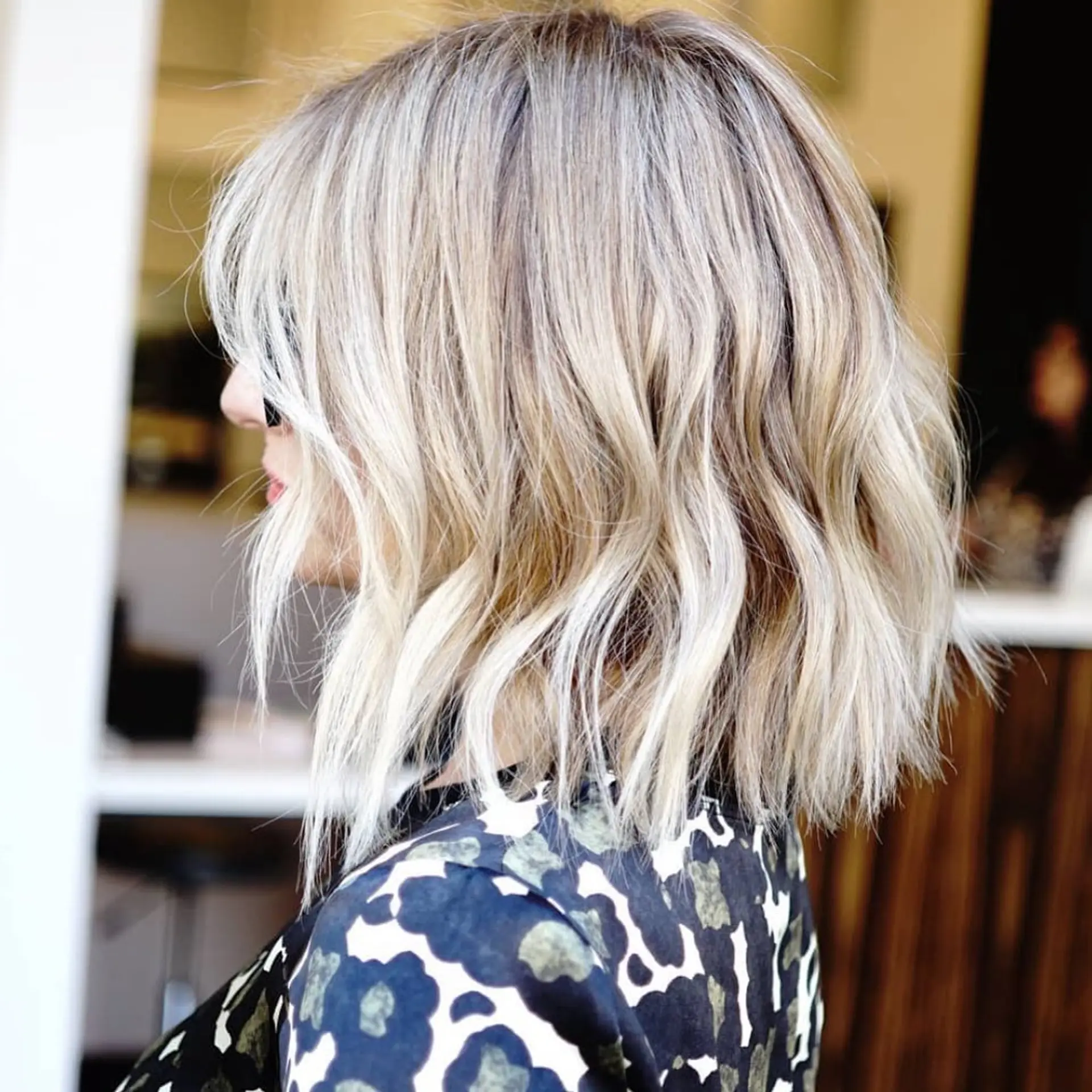 A textured wavy bob with bright blonde highlights and soft root dimension. 1