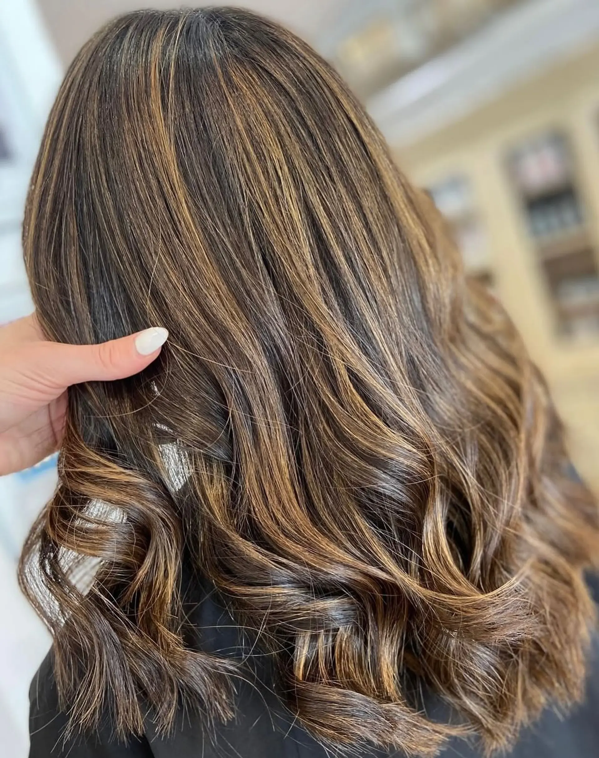 A long, wavy hairstyle with a dimensional balayage color technique. 1