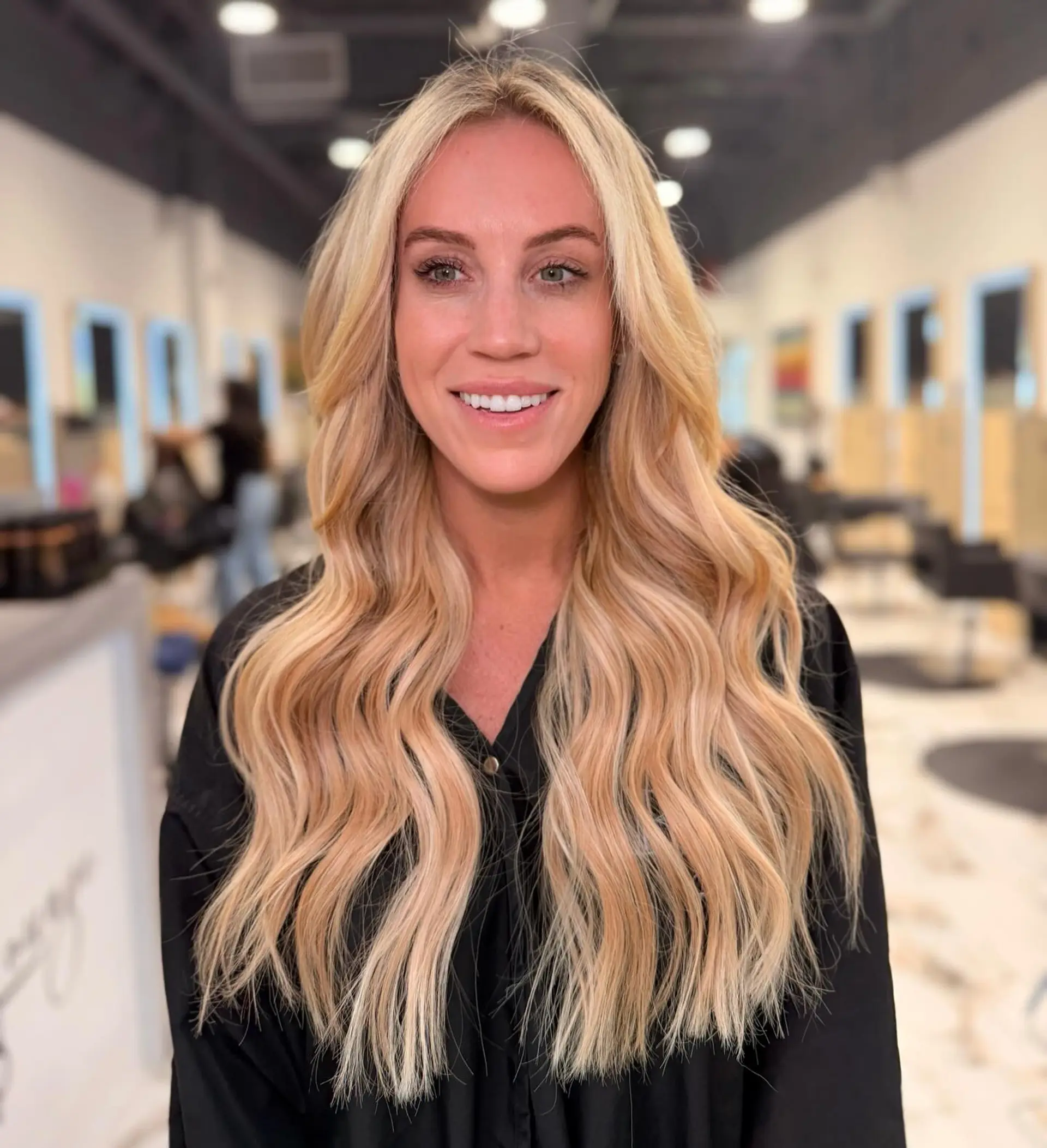 Long golden blonde hair styled in soft, loose waves with face-framing layers and seamless volume. 1