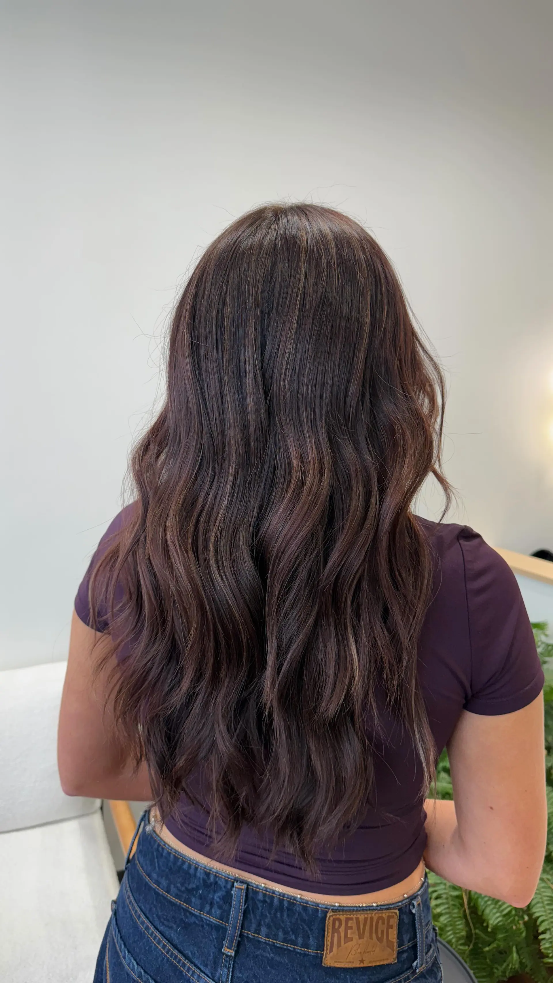 Long dimensional chocolate brunette hair styled into soft, flowing textured waves. 1