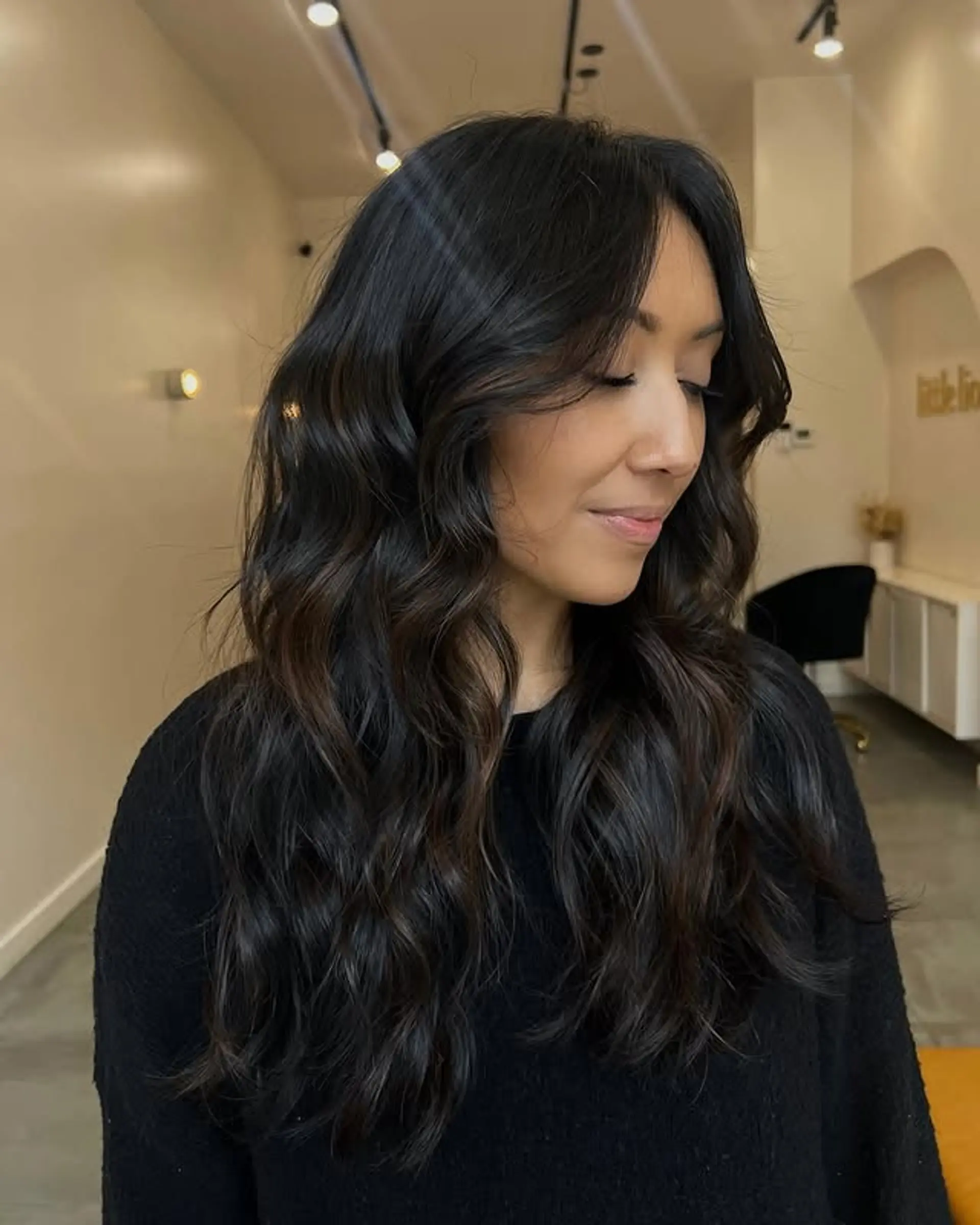 Long layered hair with soft waves and curtain bangs. 1