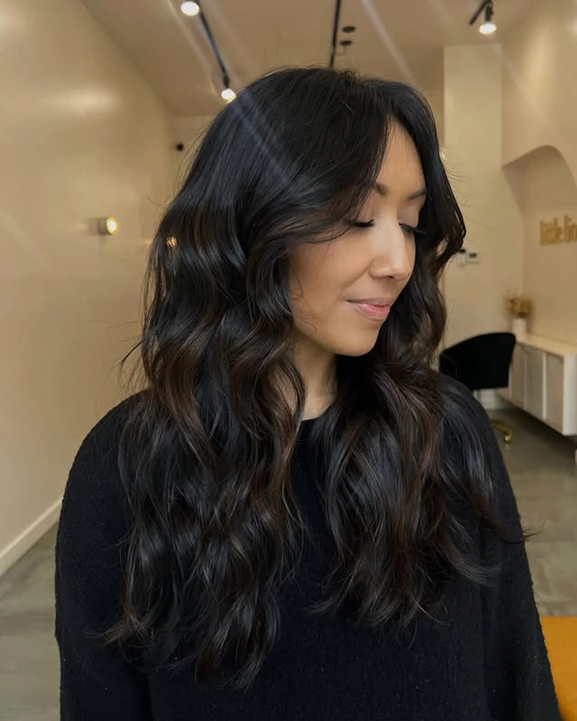A medium-length layered haircut with curtain bangs, styled with a voluminous blowout. - Preview 3
