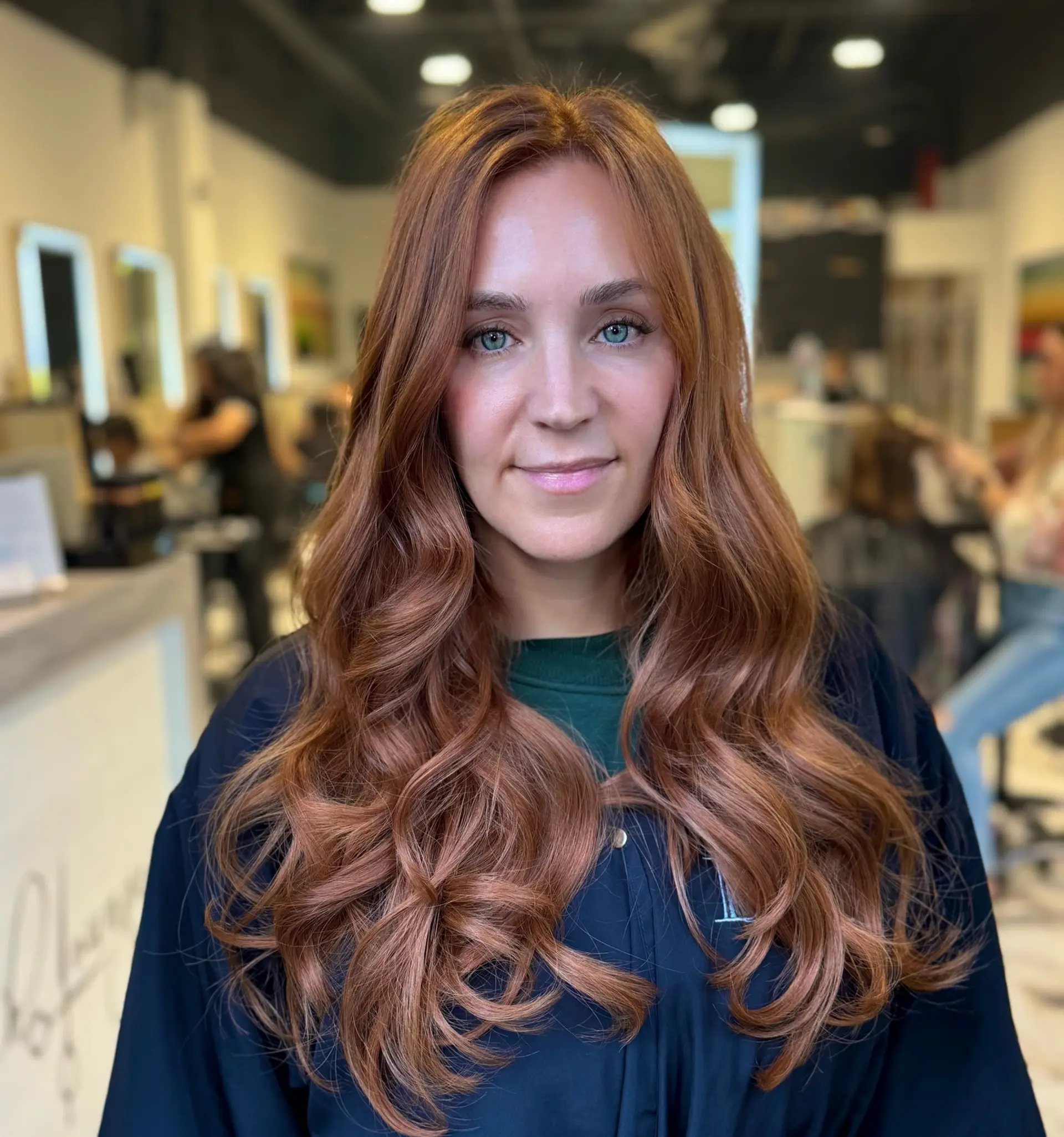 Long, vibrant copper hair styled into soft, flowing waves with seamless blended extensions for full body and volume. 1