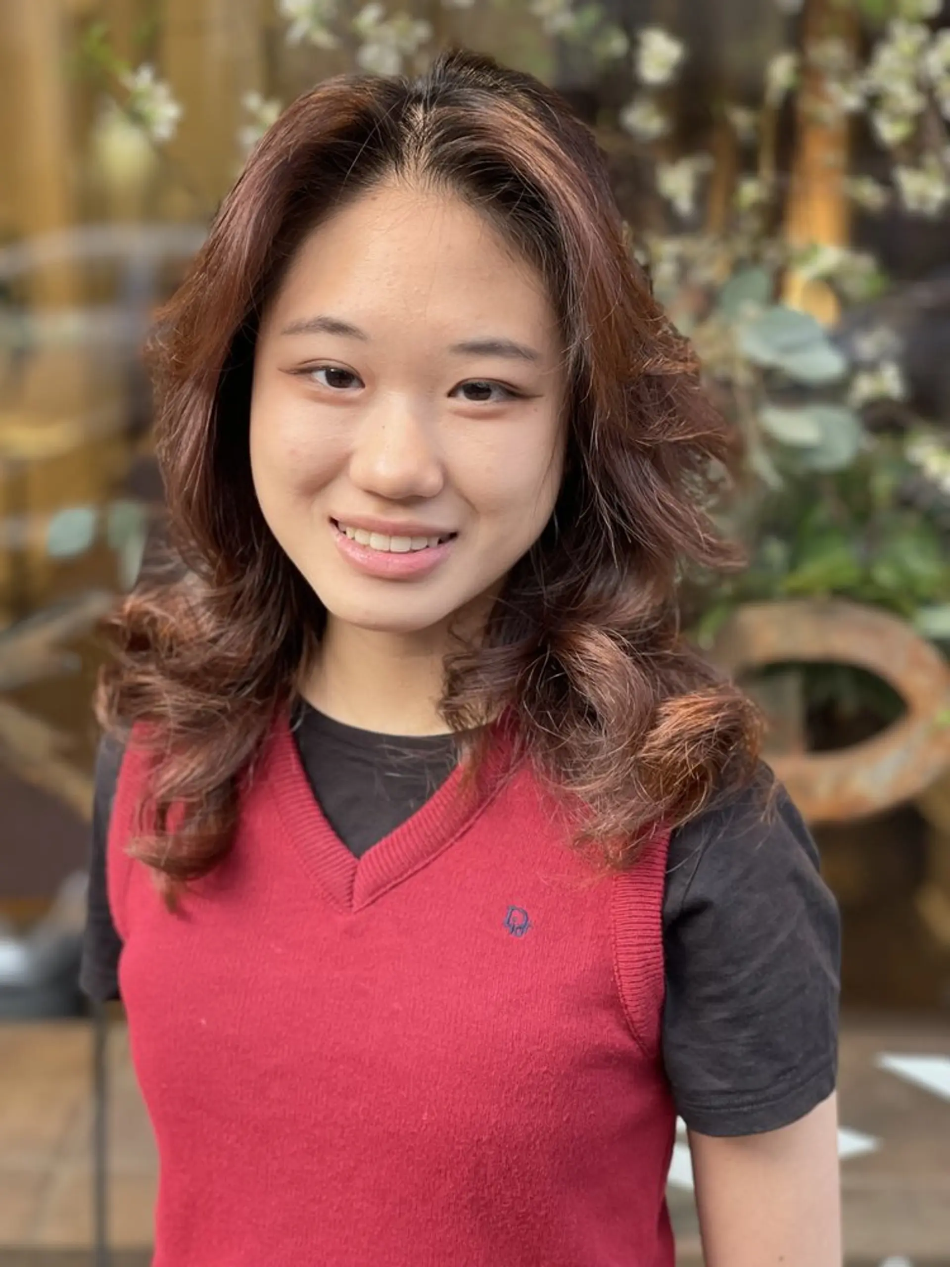 This hairstyle features soft, voluminous curls with a layered cut that enhances the natural movement and bounce. 1