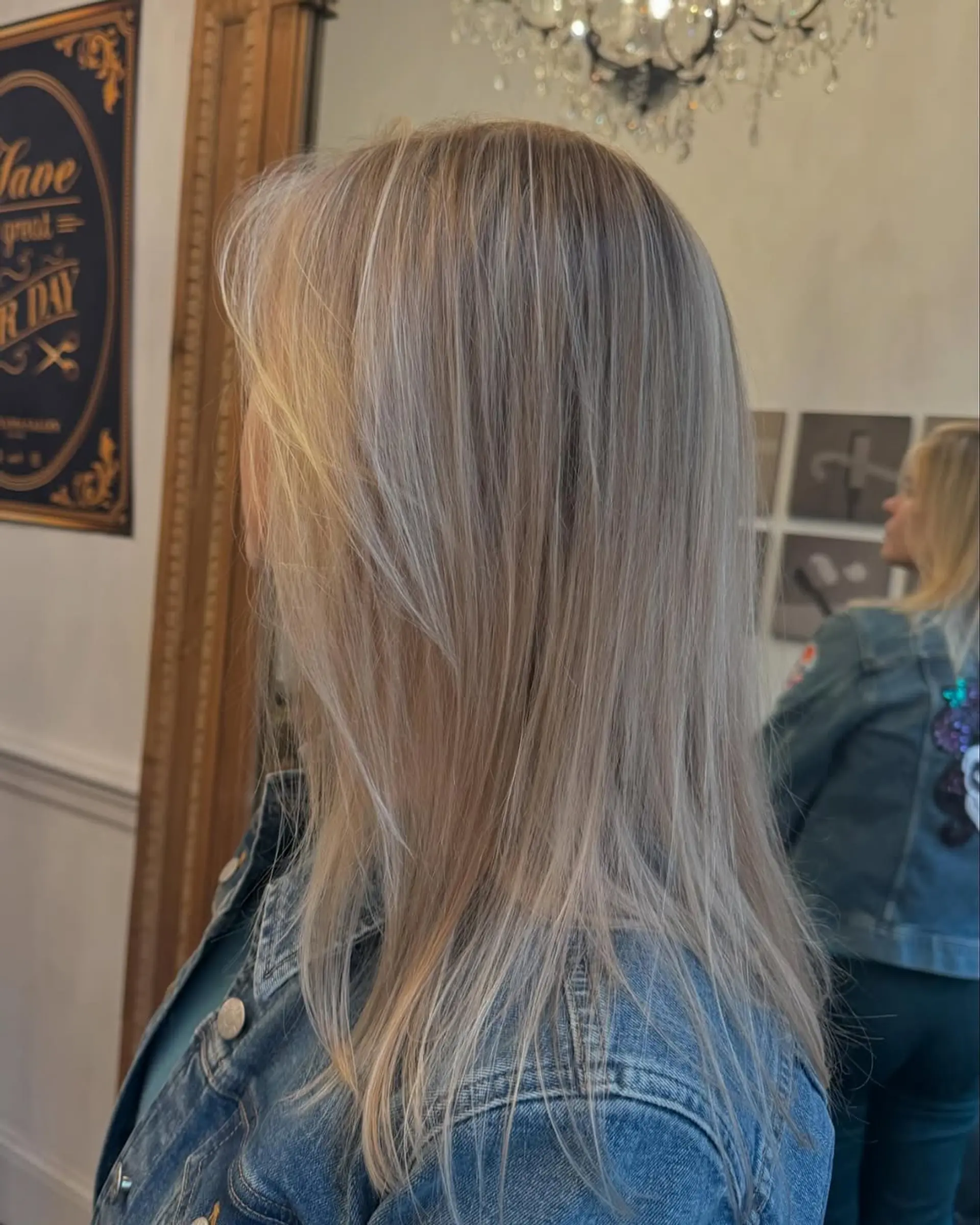 A medium-length, straight hairstyle with stunning platinum and silver blonde hues, featuring smooth layers and natural shine. 3