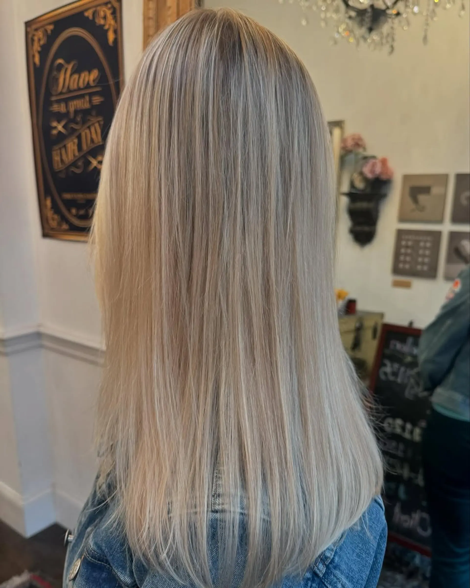 A medium-length, straight hairstyle with stunning platinum and silver blonde hues, featuring smooth layers and natural shine. 2