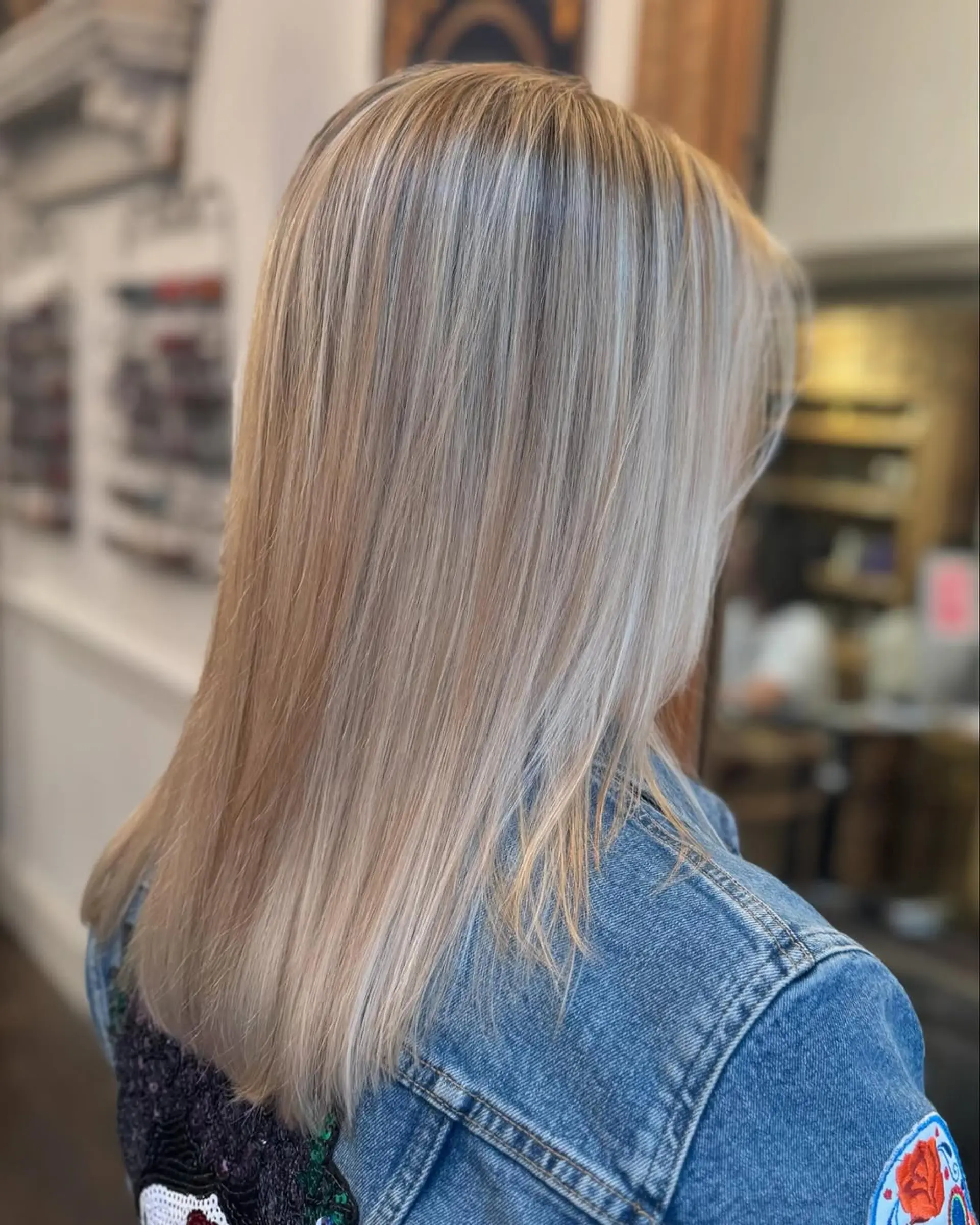 A medium-length, straight hairstyle with stunning platinum and silver blonde hues, featuring smooth layers and natural shine. 1