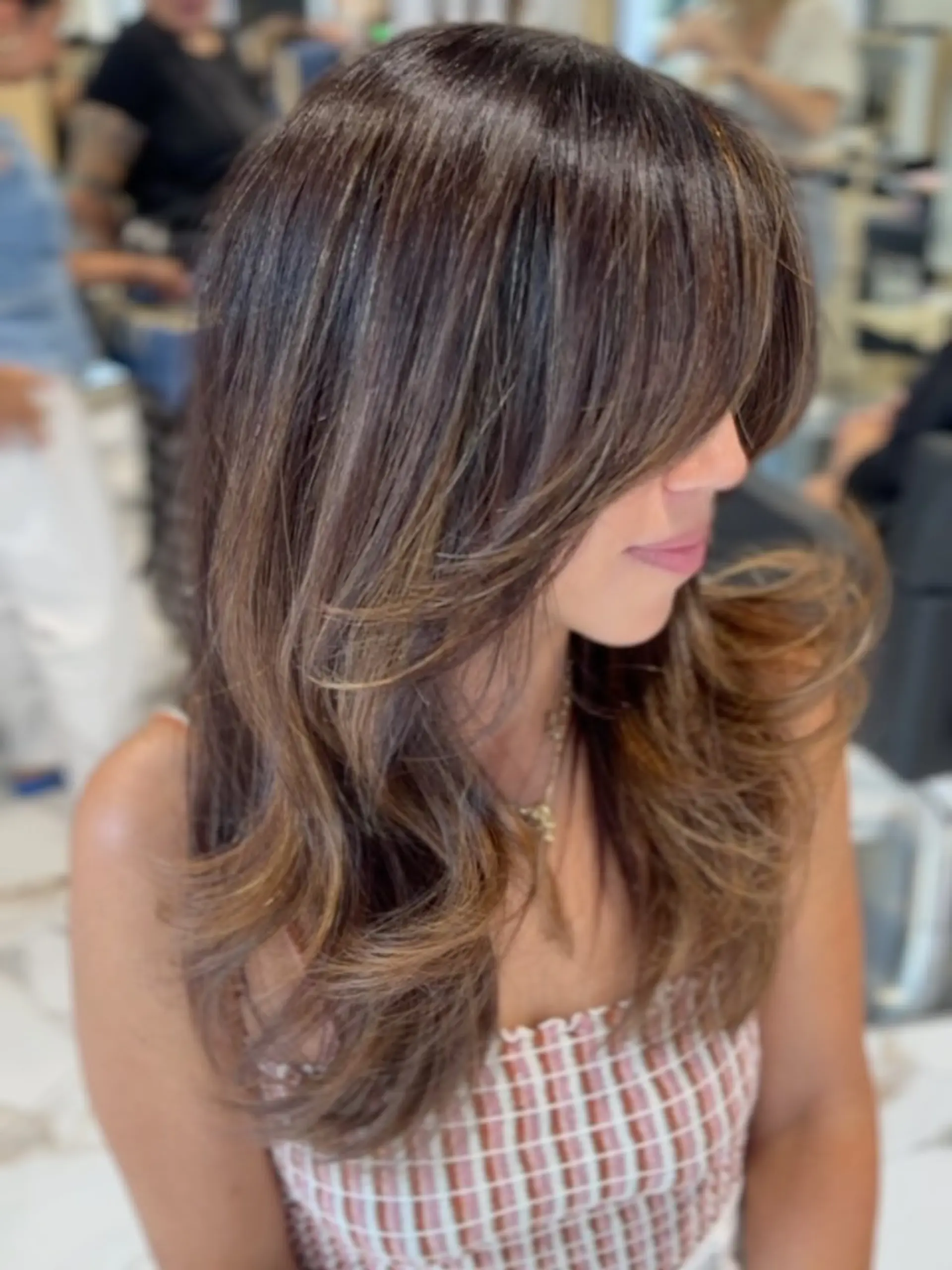 Long rich brunette cut with face-framing curtain bangs and voluminous, polished layered ends. 1