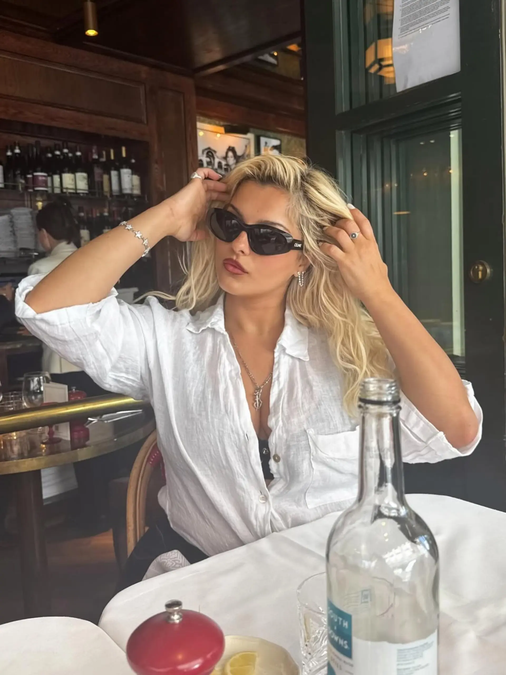 Long platinum blonde hair styled with loose, voluminous waves and body. 1