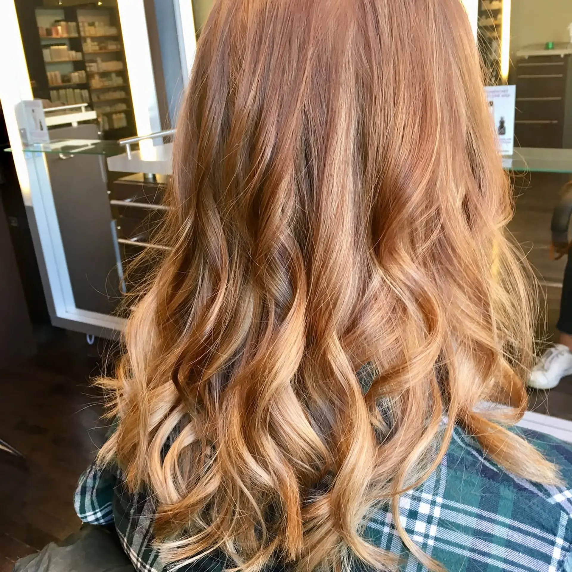 A wavy, medium-length hairstyle featuring a copper base with blonde balayage highlights. 1