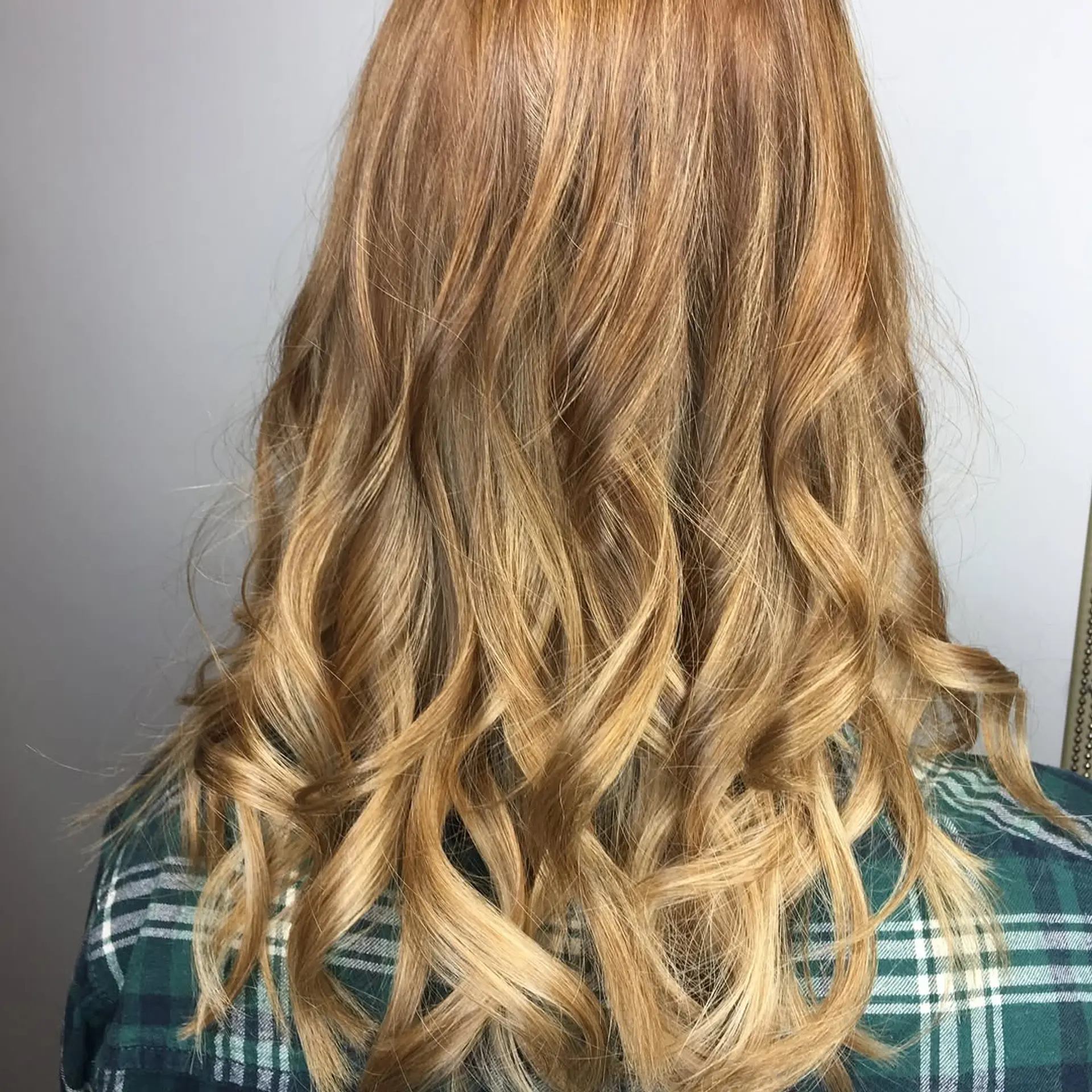 A wavy, medium-length hairstyle featuring a copper base with blonde balayage highlights. 2