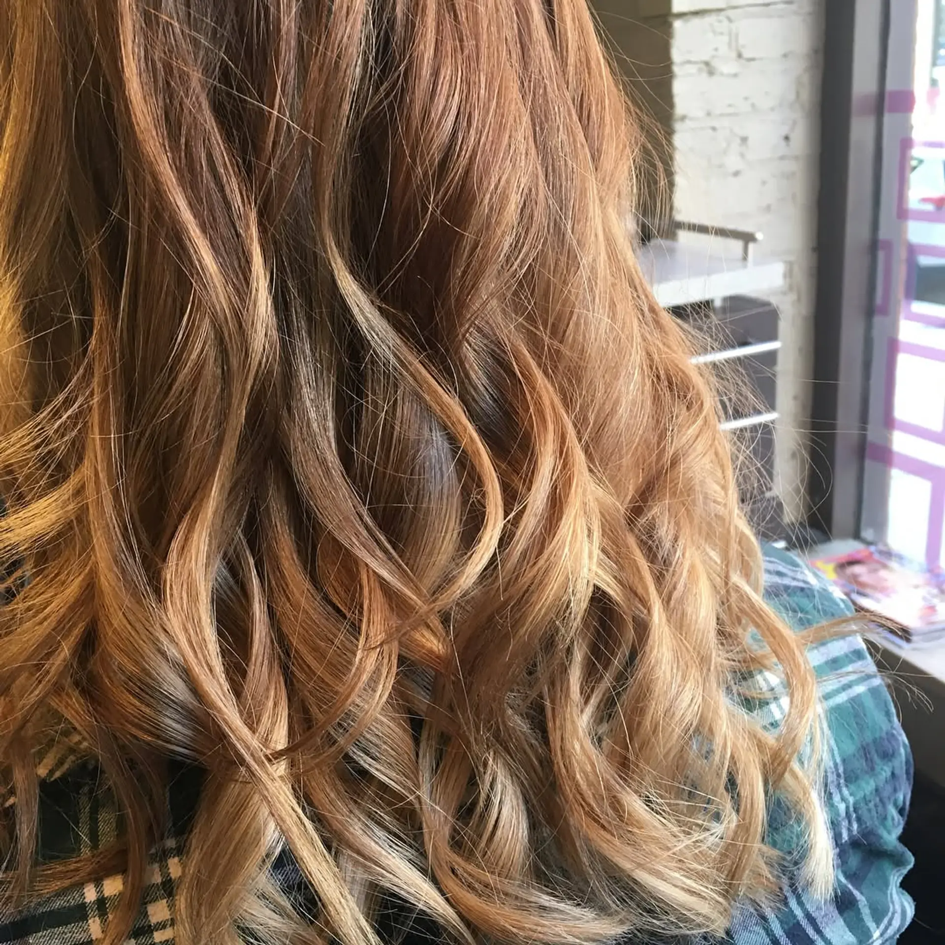 A wavy, medium-length hairstyle featuring a copper base with blonde balayage highlights. 3