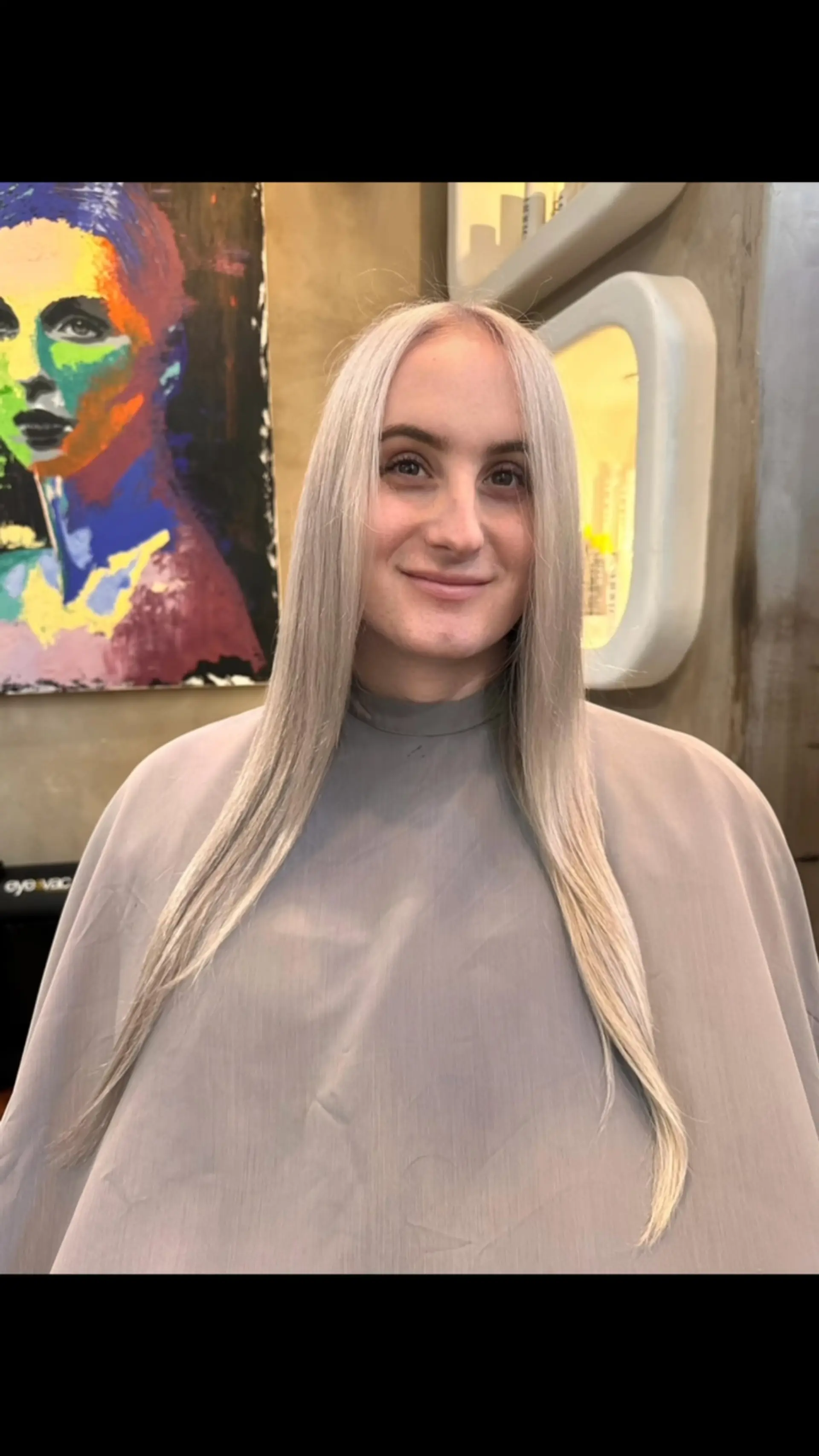 Long, sleek, straight icy platinum blonde hair styled with a center part. 1