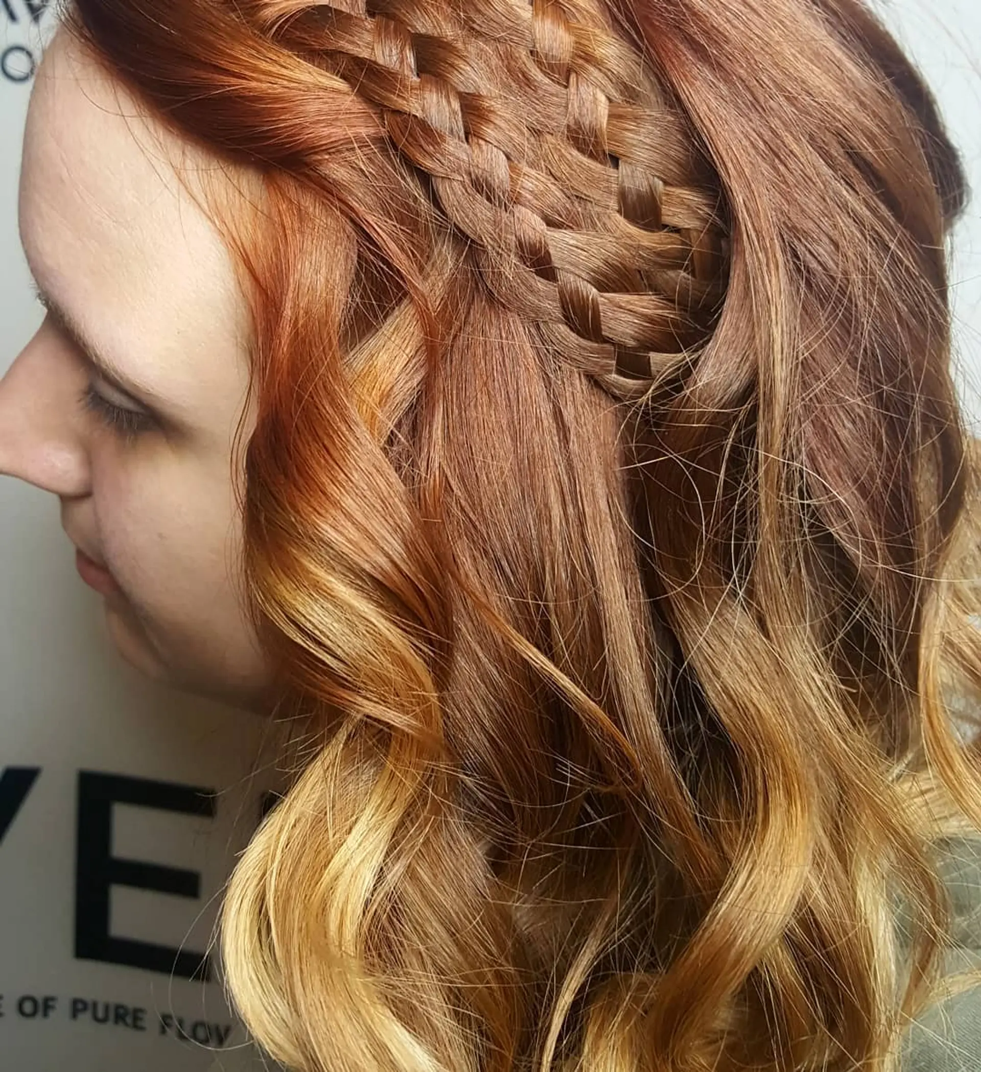 An intricate multi-strand woven basket braid detailed along the side of vibrant copper hair styled into loose, flowing waves. 1