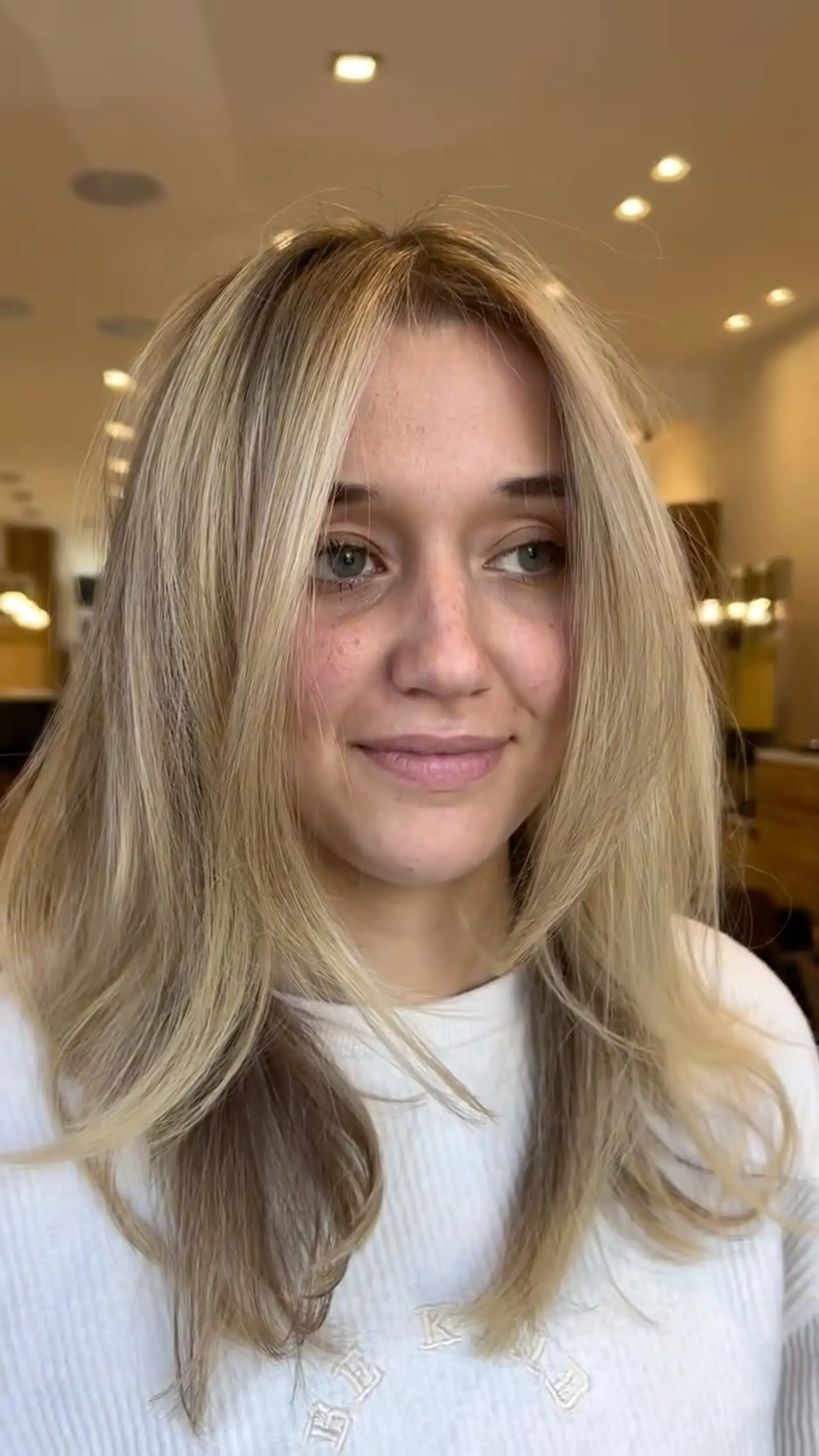 Medium-length dimensional blonde hair with soft face-framing curtain layers and a smooth, voluminous blowout finish. 1