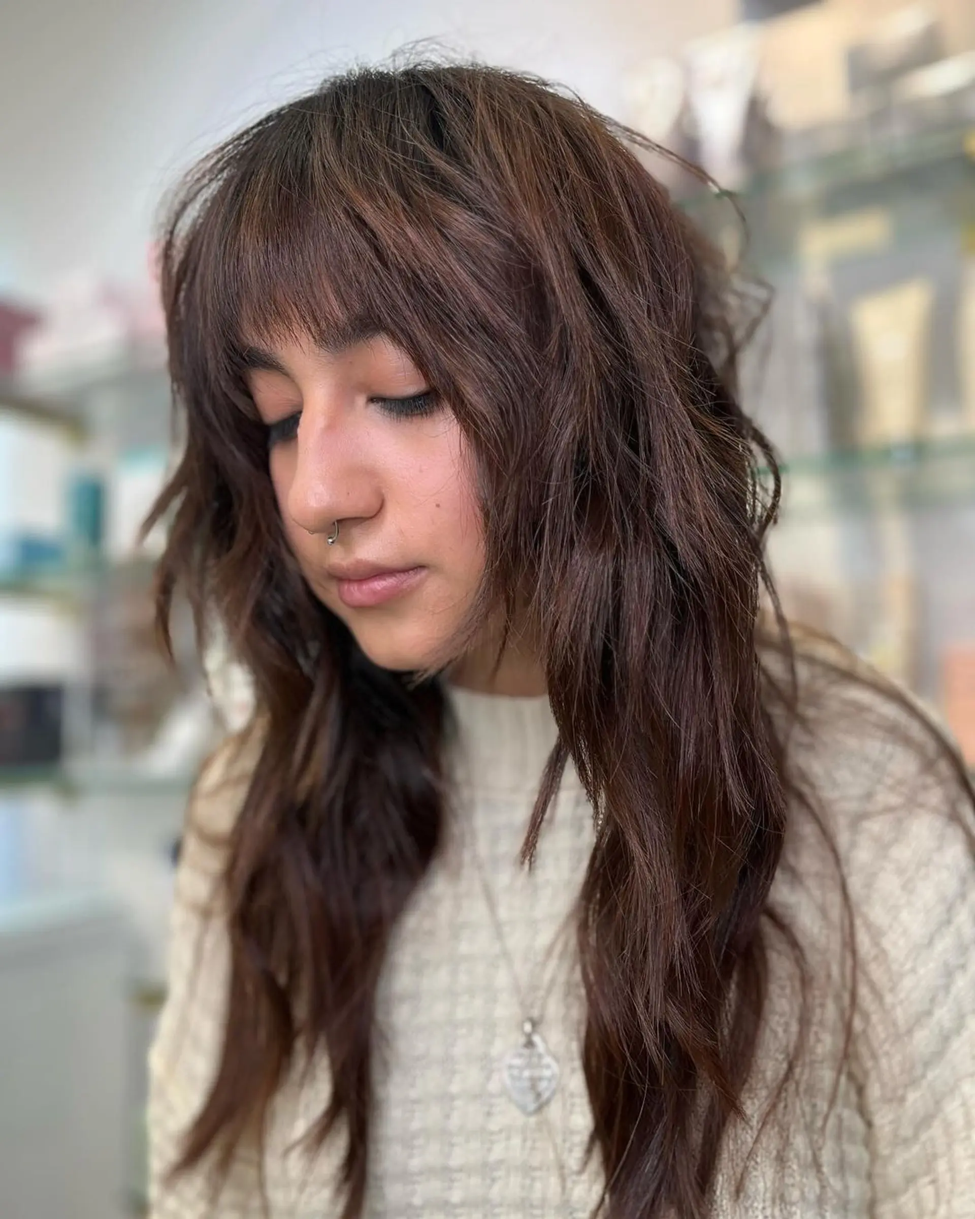 Chestnut brown, long, wavy hair with bohemian waves, textured layers, and fringe bangs, embodying an earthy, boho chic vibe with a soft texture. 1