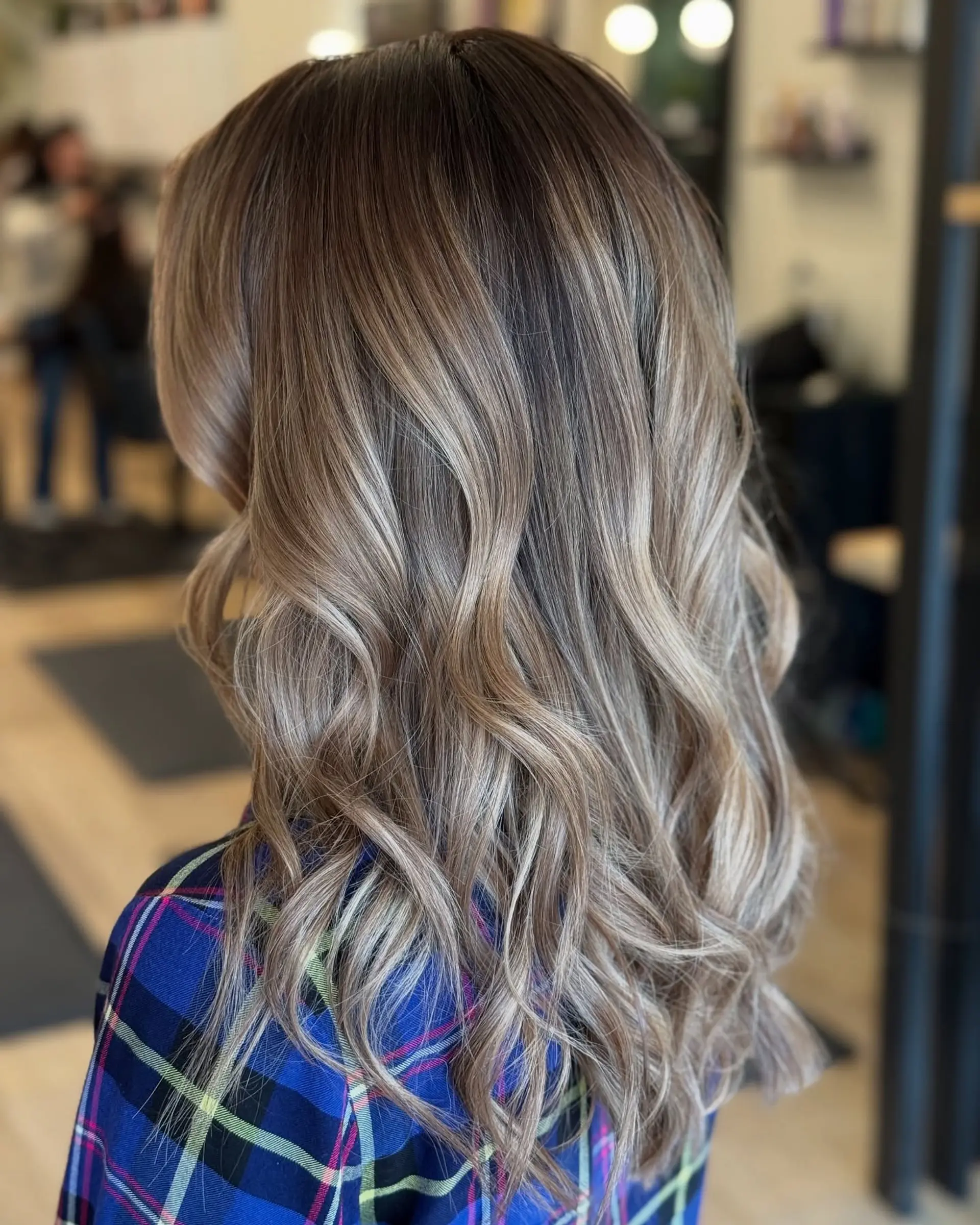 Long hair featuring a seamless ash blonde balayage styled in soft, loose waves. 1