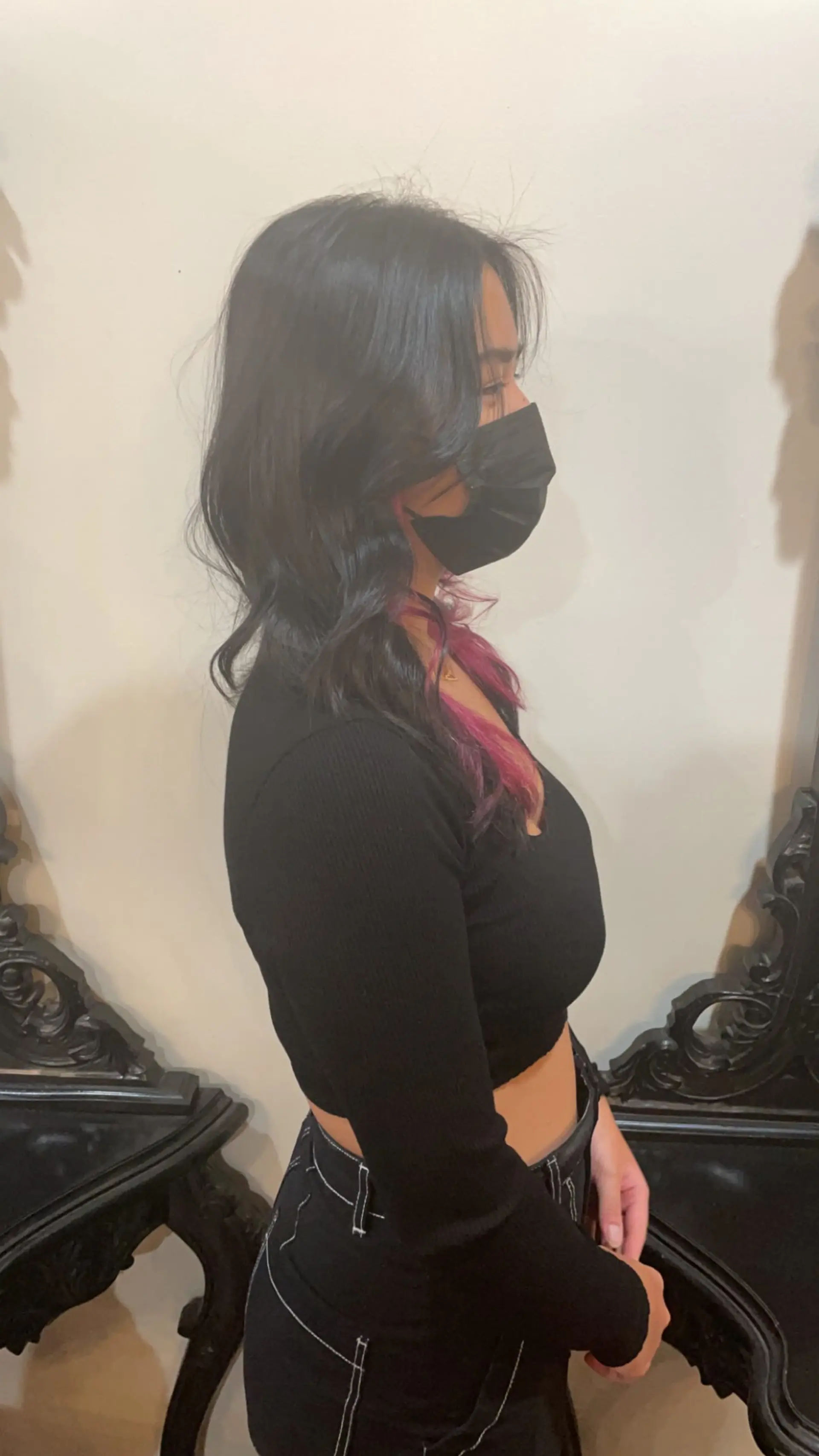 Medium-length dark hair cut with face-framing layers and soft waves, featuring vibrant peek-a-boo pink coloring underneath. 1