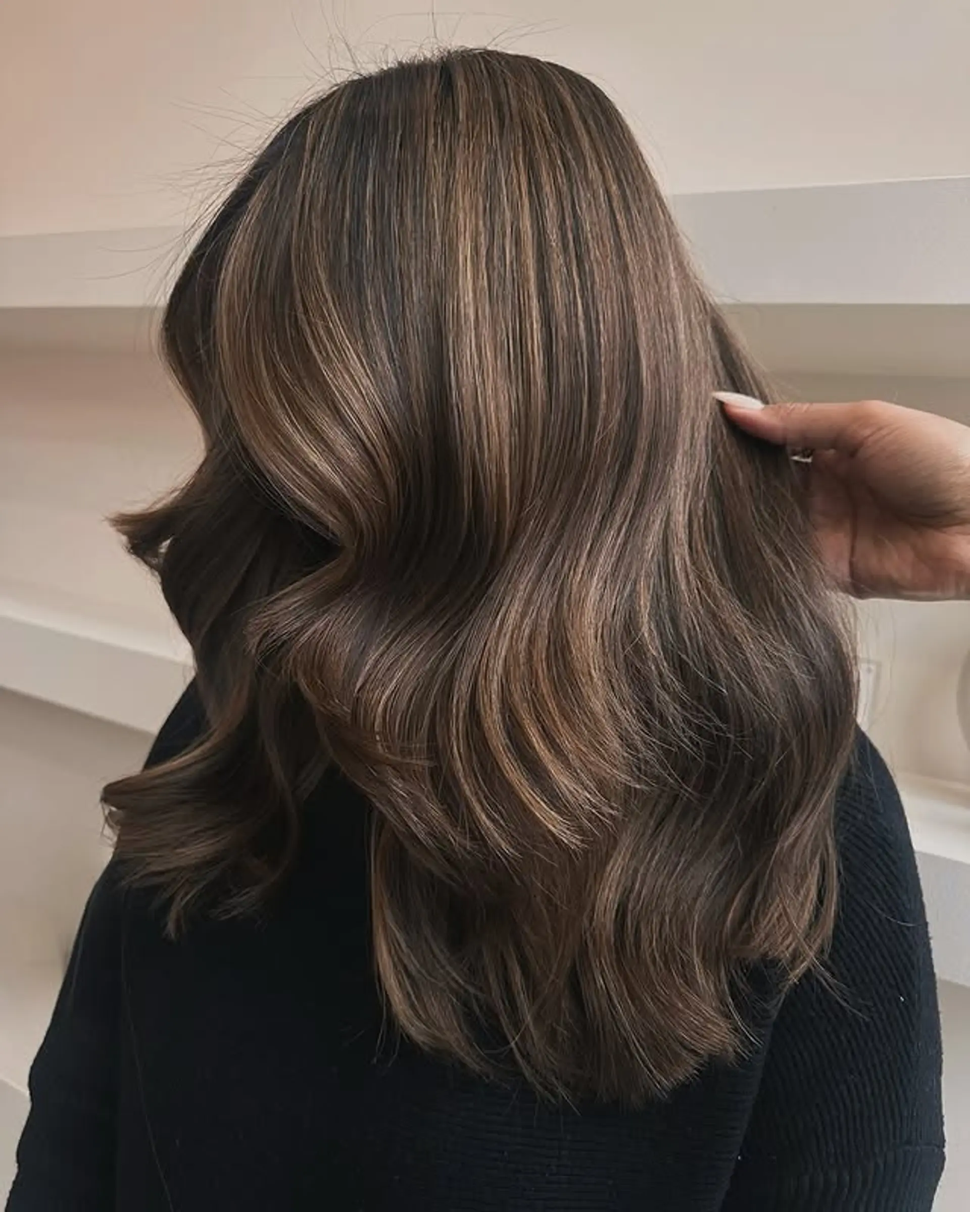 A wavy hairstyle with a bronzed balayage. 1