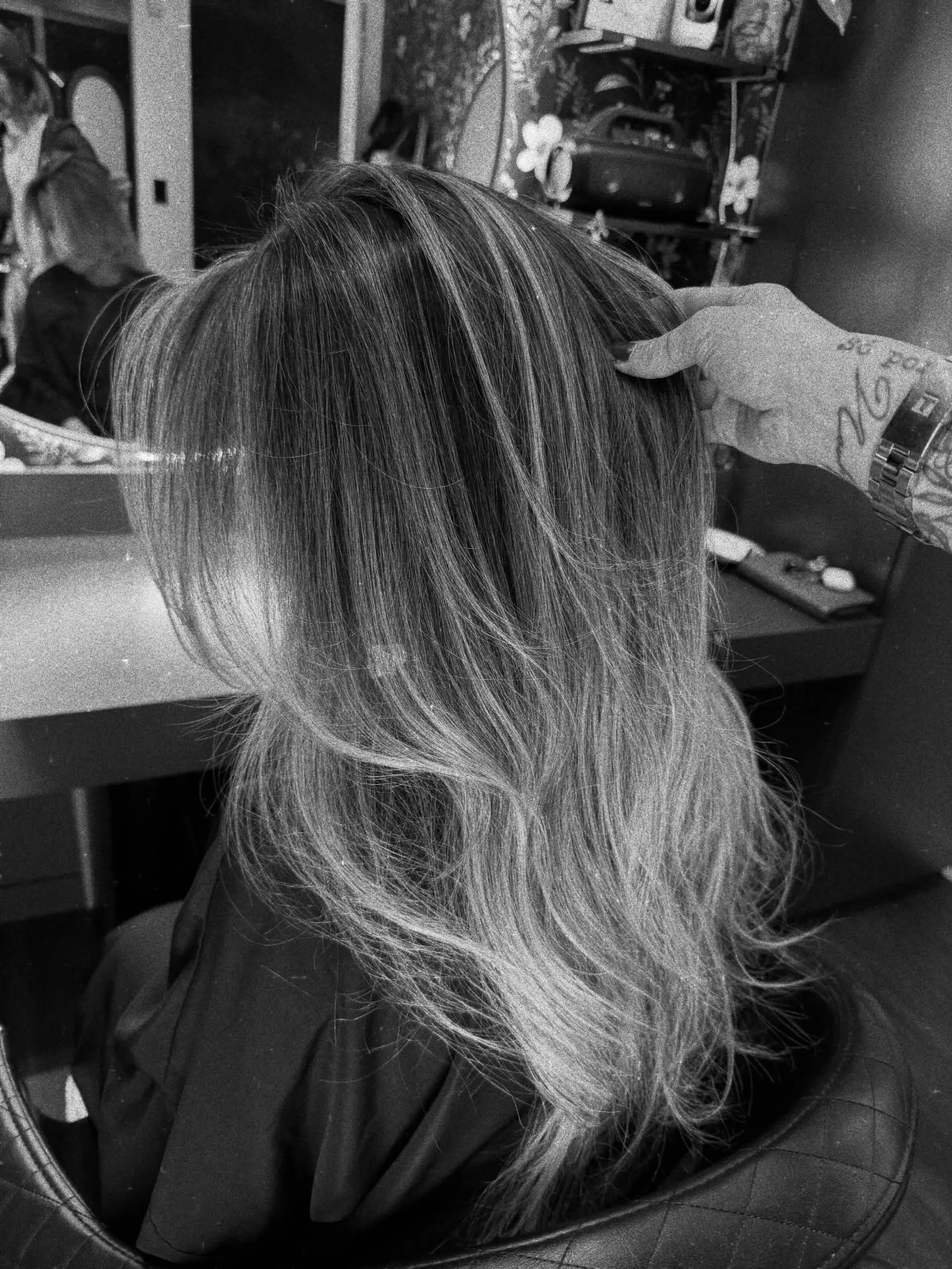 Long layered hair styled with soft, flowing waves and visible dimensional highlights. 1