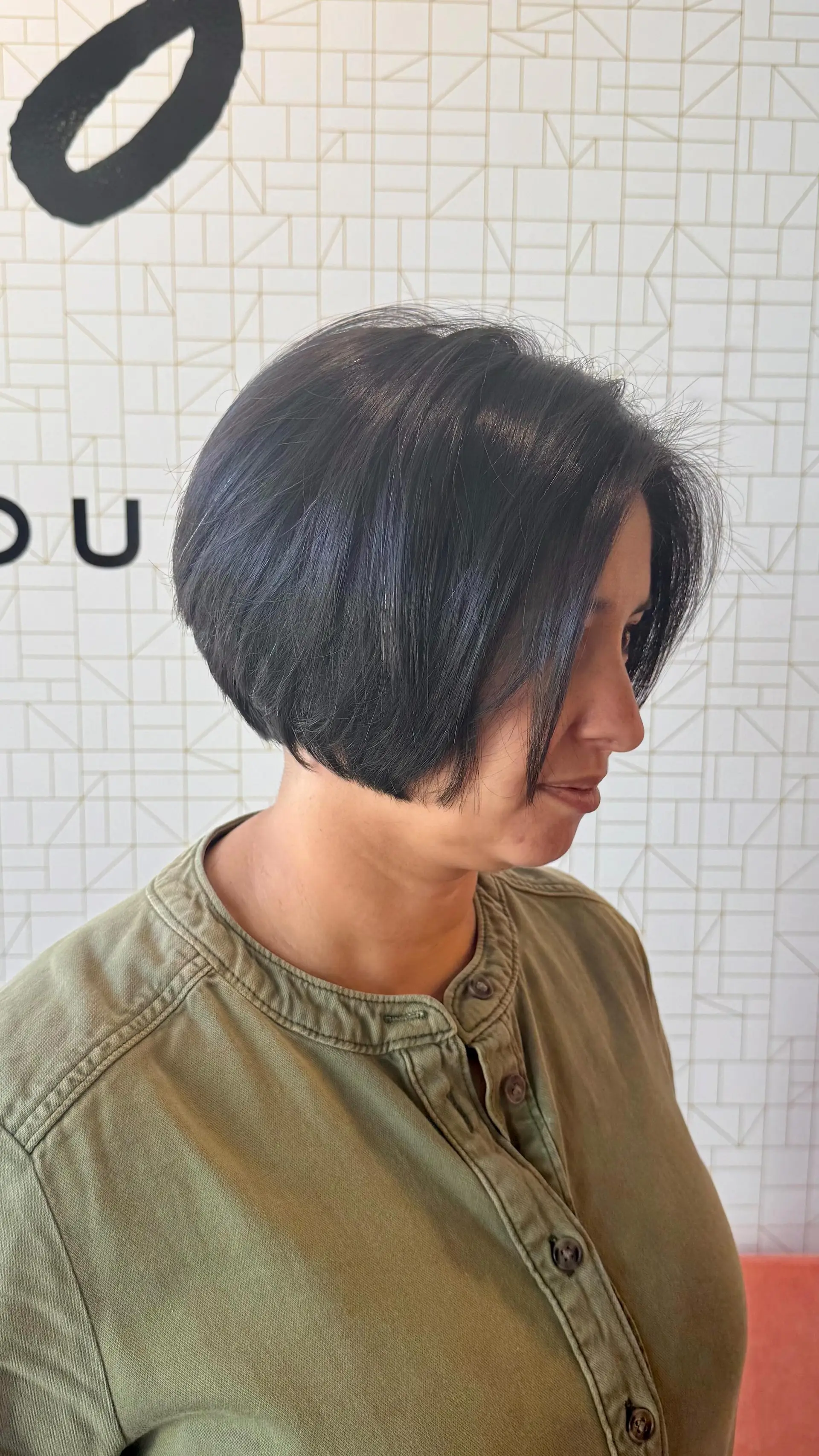 A sleek, chin-length rounded bob haircut with subtle face-framing layers in a deep natural black shade. 1