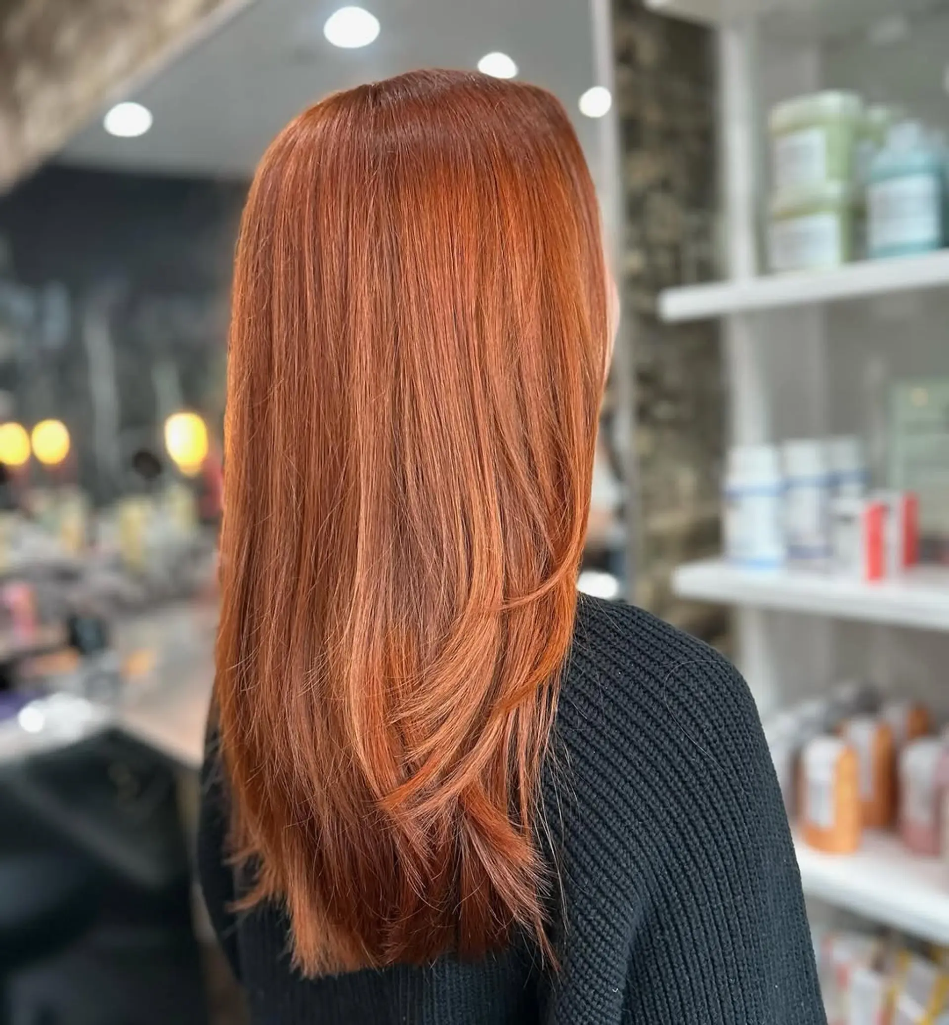 A stunning long hairstyle showcasing a rich, vibrant copper red color with sleek, straight texture and subtle layering around the ends to add movement and shape. 1