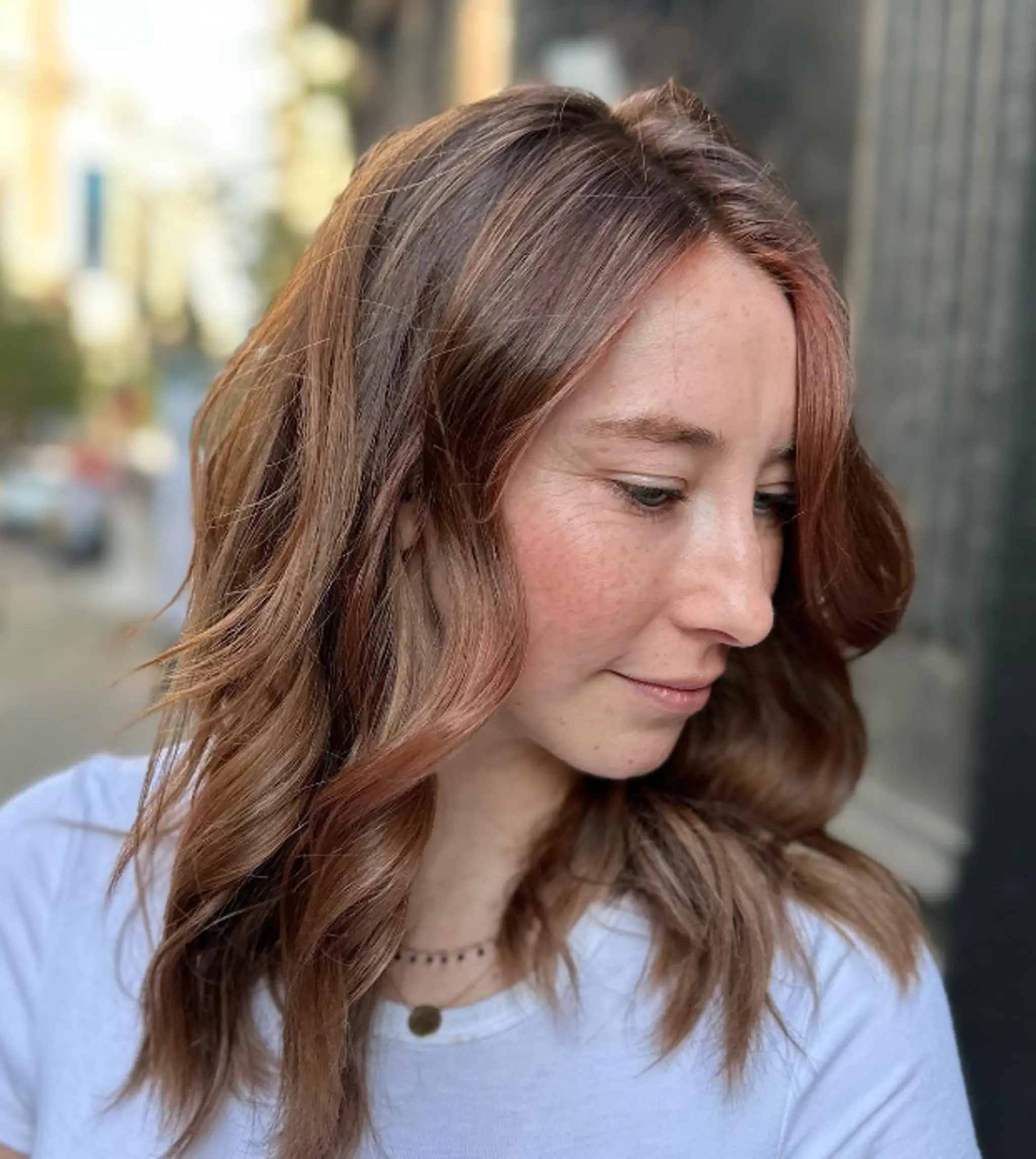 Medium-length, wavy hairstyle with soft waves, featuring a mix of light brown and reddish-brown tones. Layered cut with a side part, creating a natural and effortless look.

Color by @simabeautynyc
Cut and style by @juliamannino_hair
 2