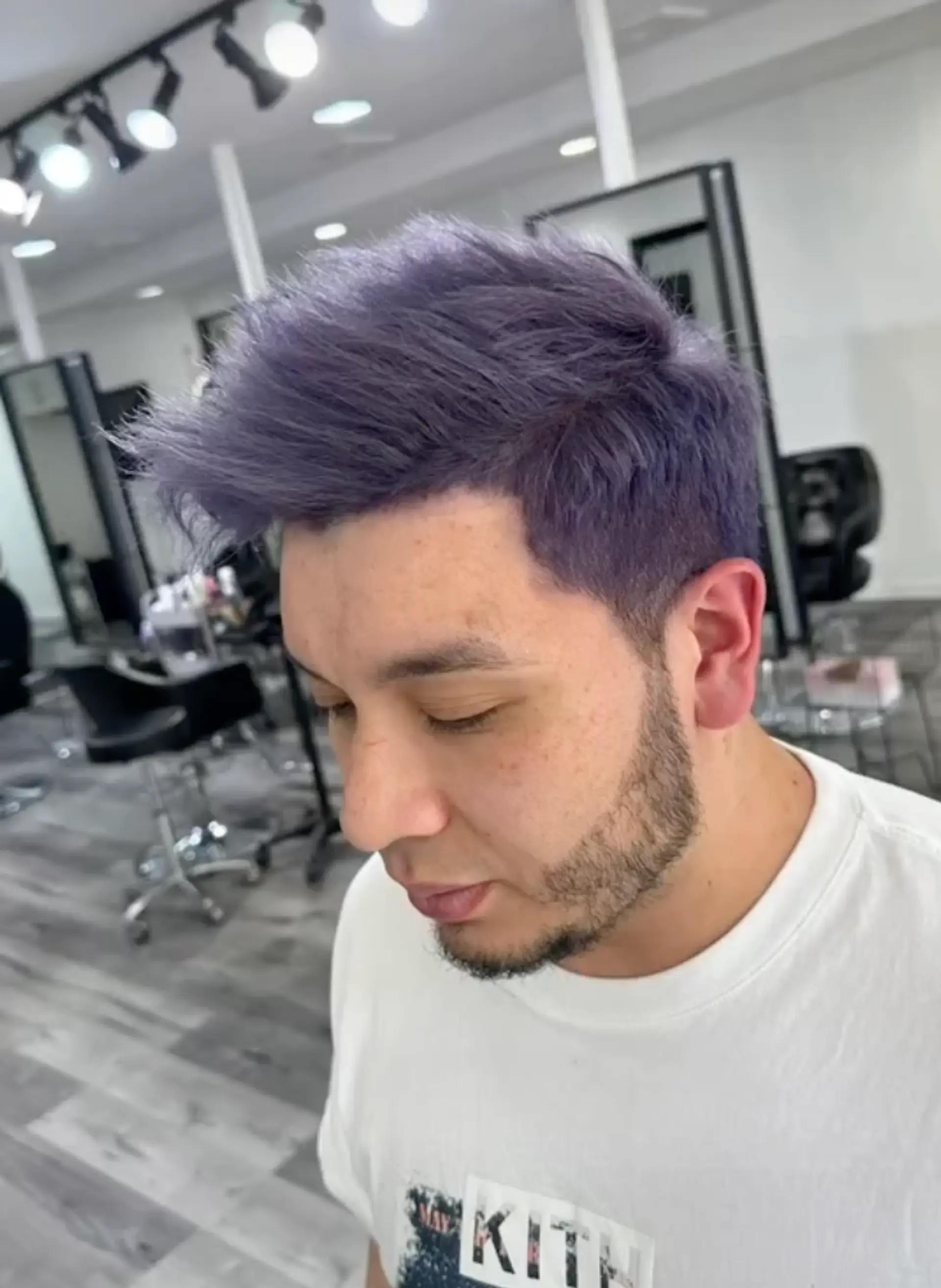 A vibrant short hairstyle with a purple color. The hair is straight and has a textured top, styled upward with a spiky effect, combined with neat side fades. 2