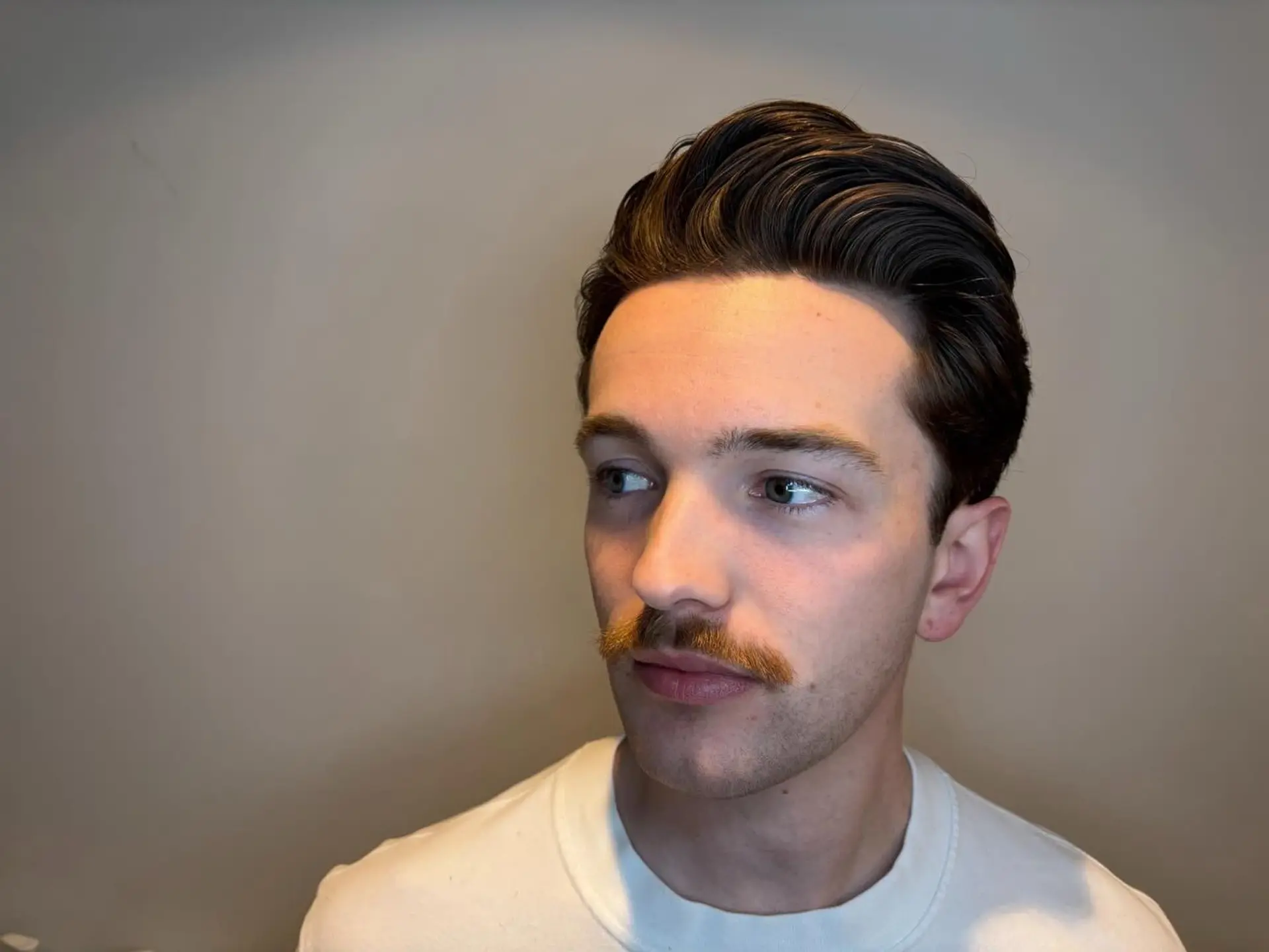 A refined men's haircut styled into a voluminous, swept-back pompadour with clean, tapered sides. 1