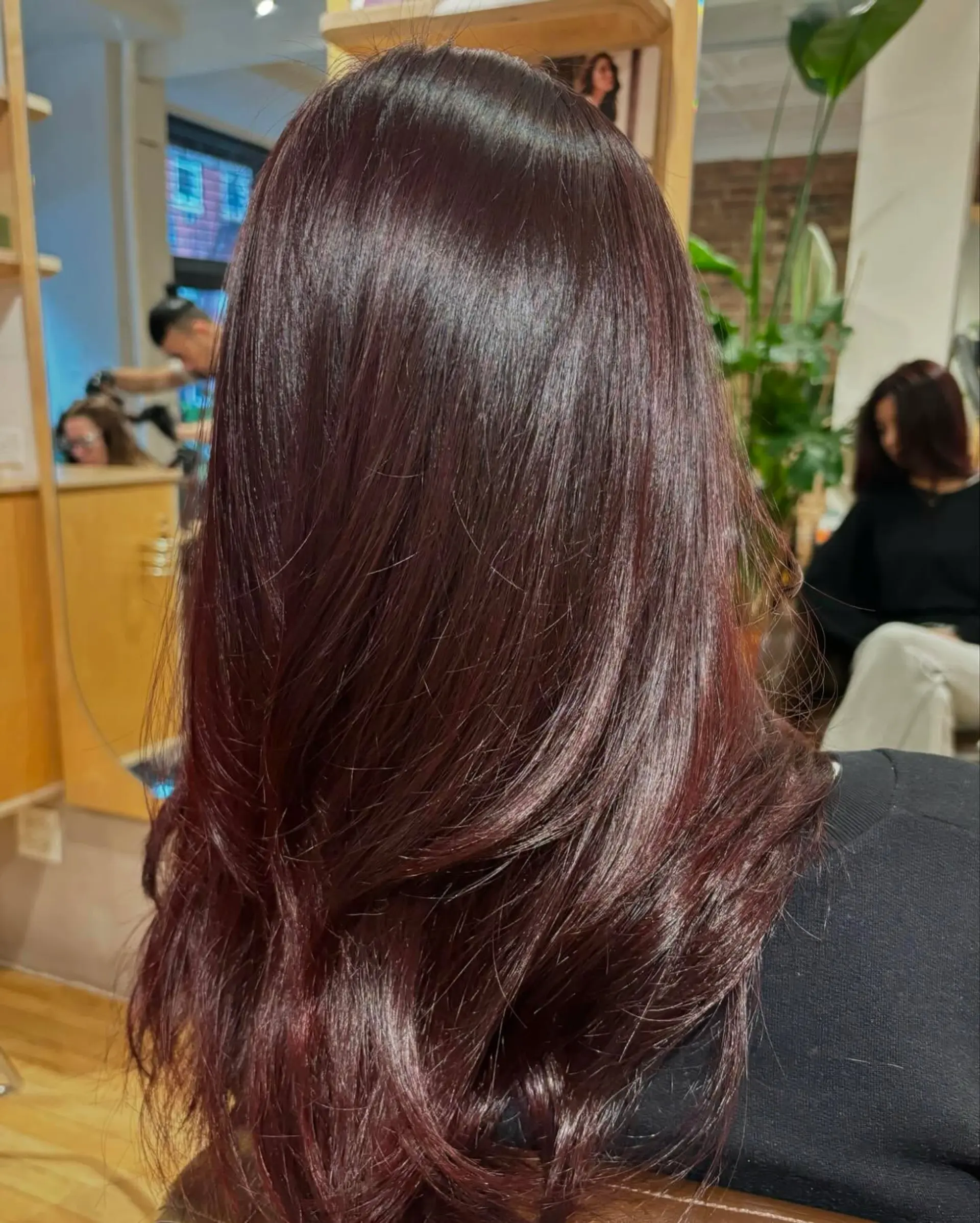 A rich, lustrous red-brown color styled in a smooth, polished blowout with softly curved ends. 1