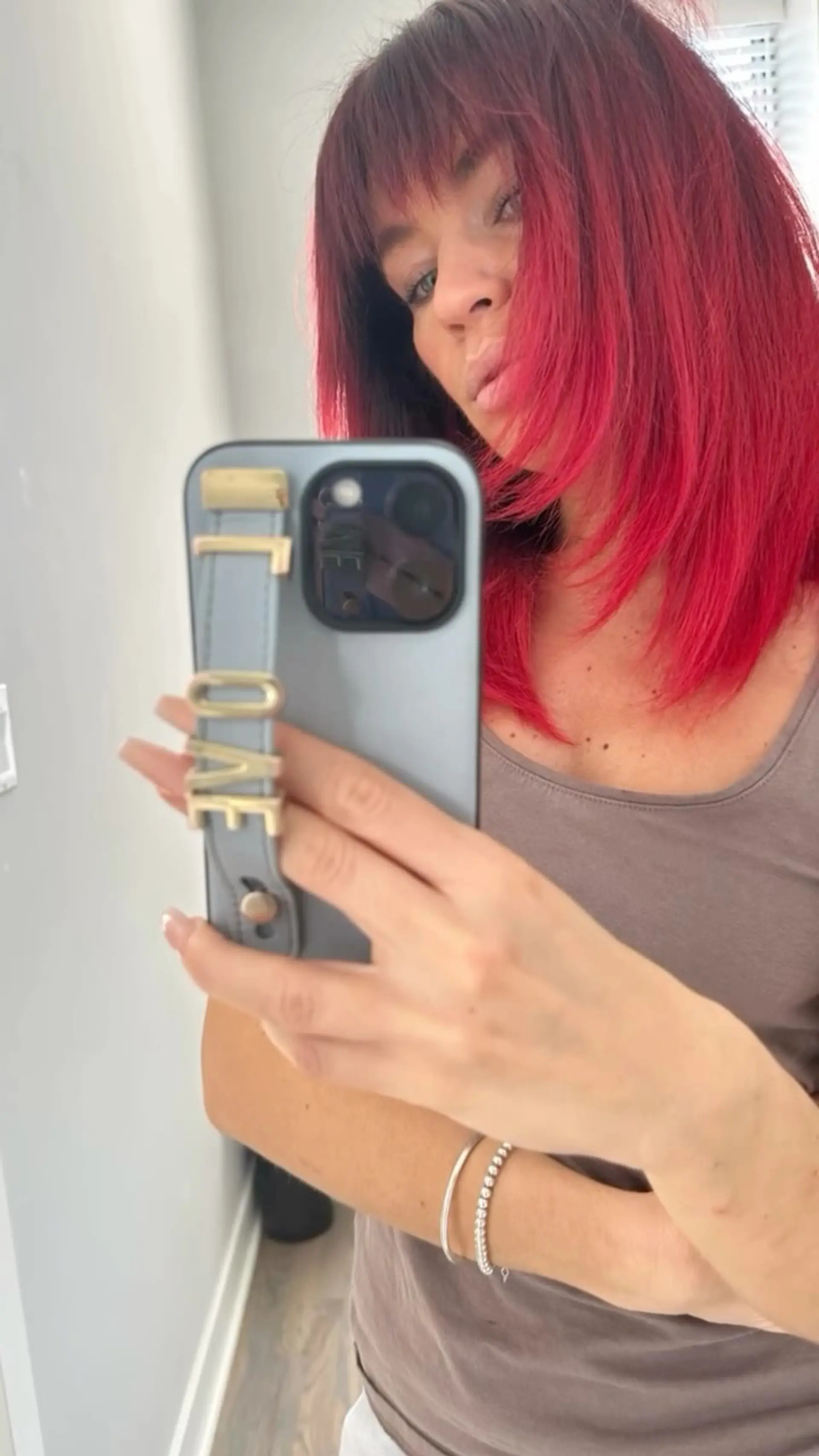 A vibrant crimson-red medium-length cut styled straight with soft, wispy bangs. 1