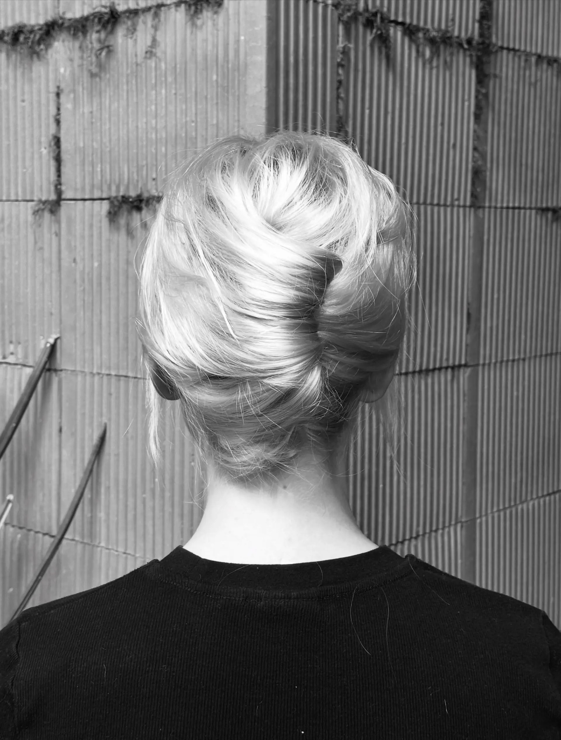 A chic French twist updo with smooth, soft texture gathered cleanly along the back of the head. 1