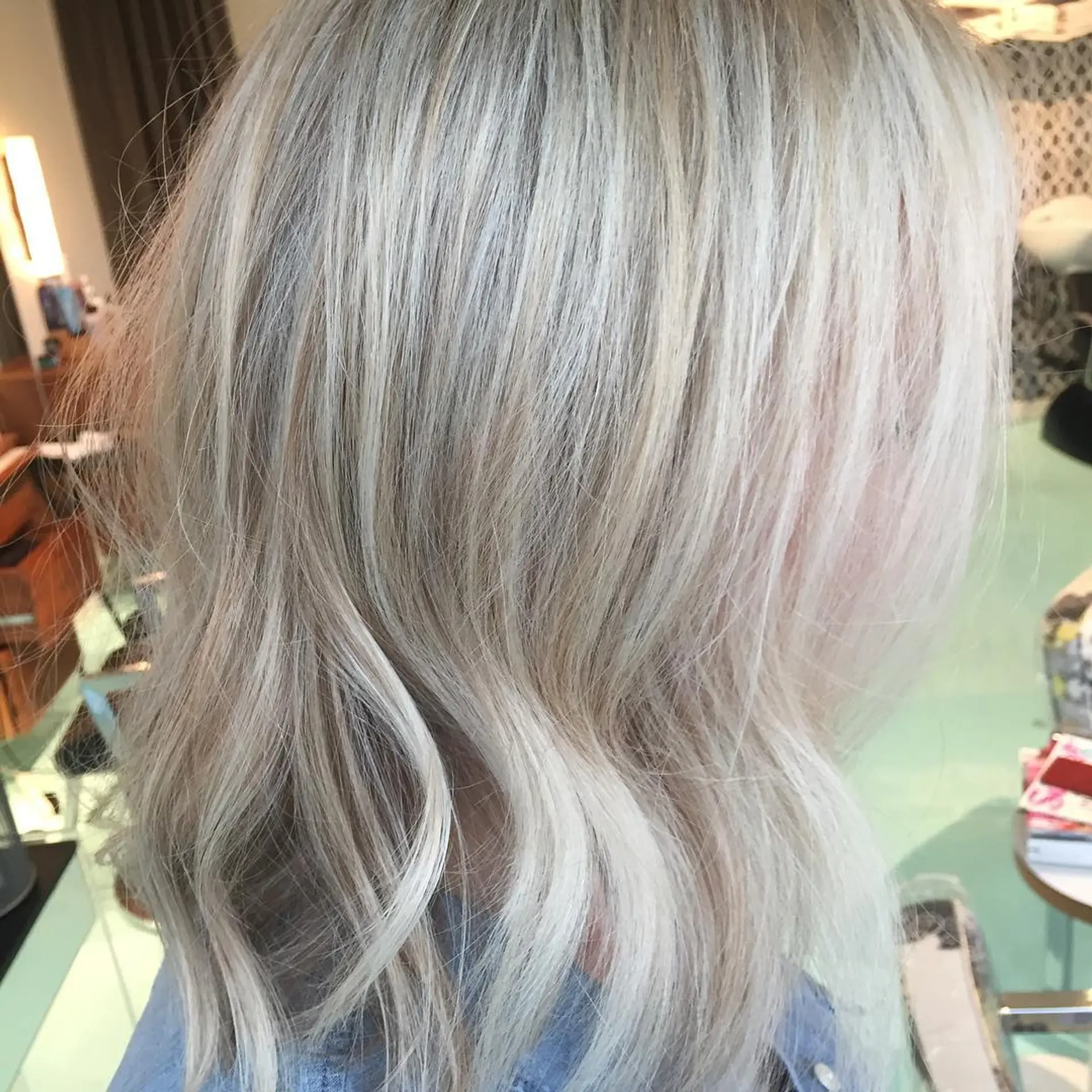 Medium-length bright platinum blonde lob styled with gentle textured waves. 1