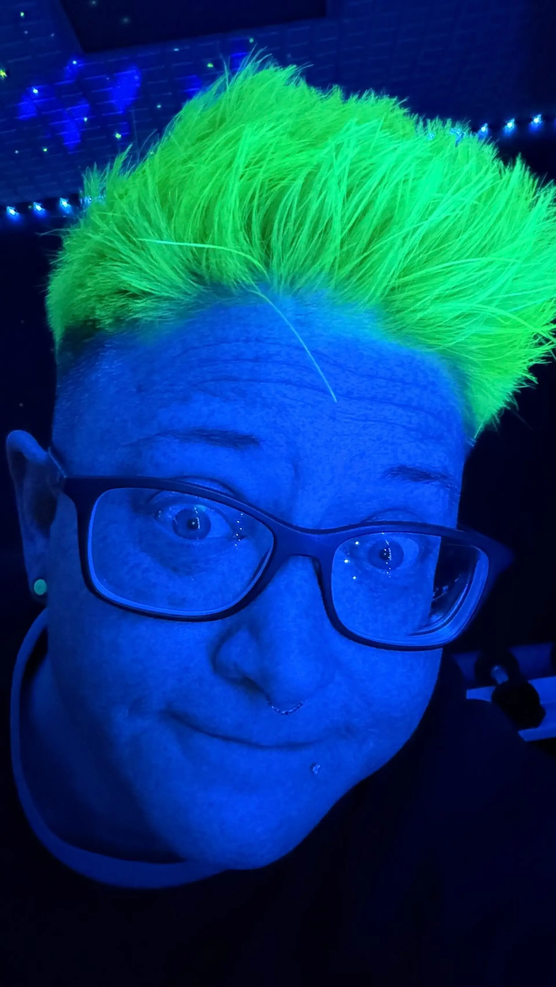 A short textured crop dyed in a vibrant UV-reactive neon green that glows under blacklight. 1