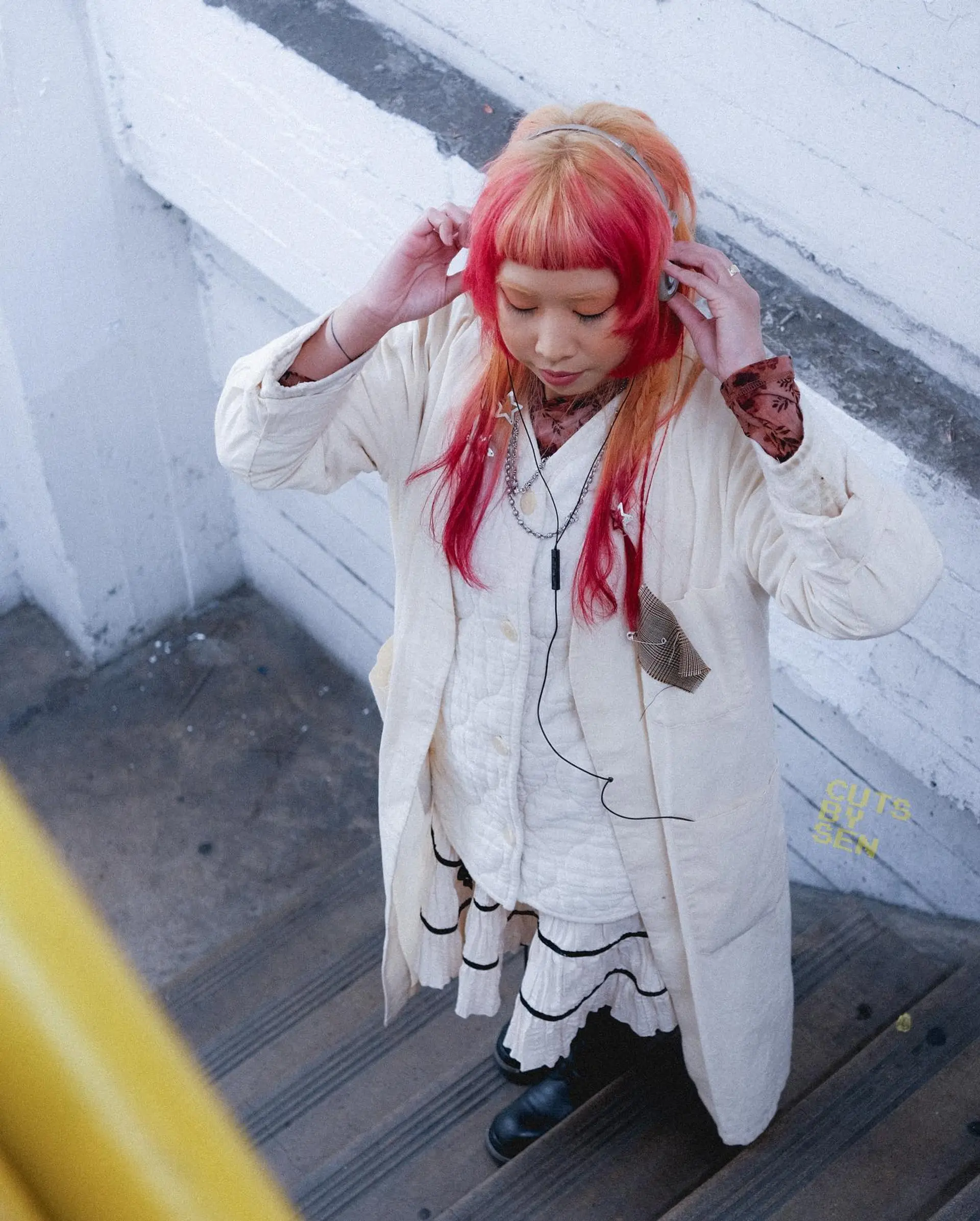 A modern, edgy variation of the hime cut featuring micro bangs, stepped face-framing layers, and longer textured lengths with vibrant pink and peach coloring. 1