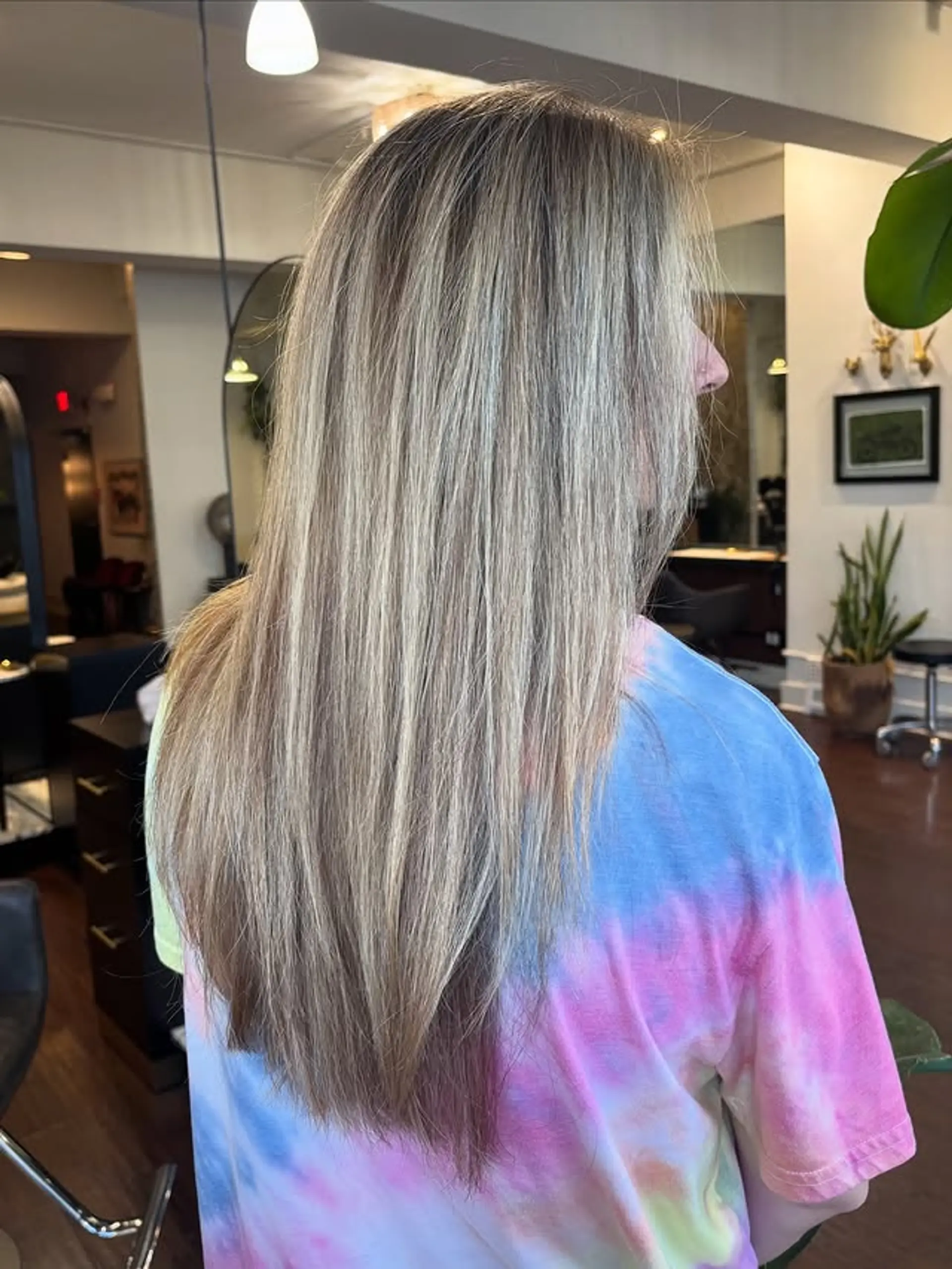 A long layered haircut with a subtle face frame and a balayage featuring icy blonde tones for a modern style. 1
