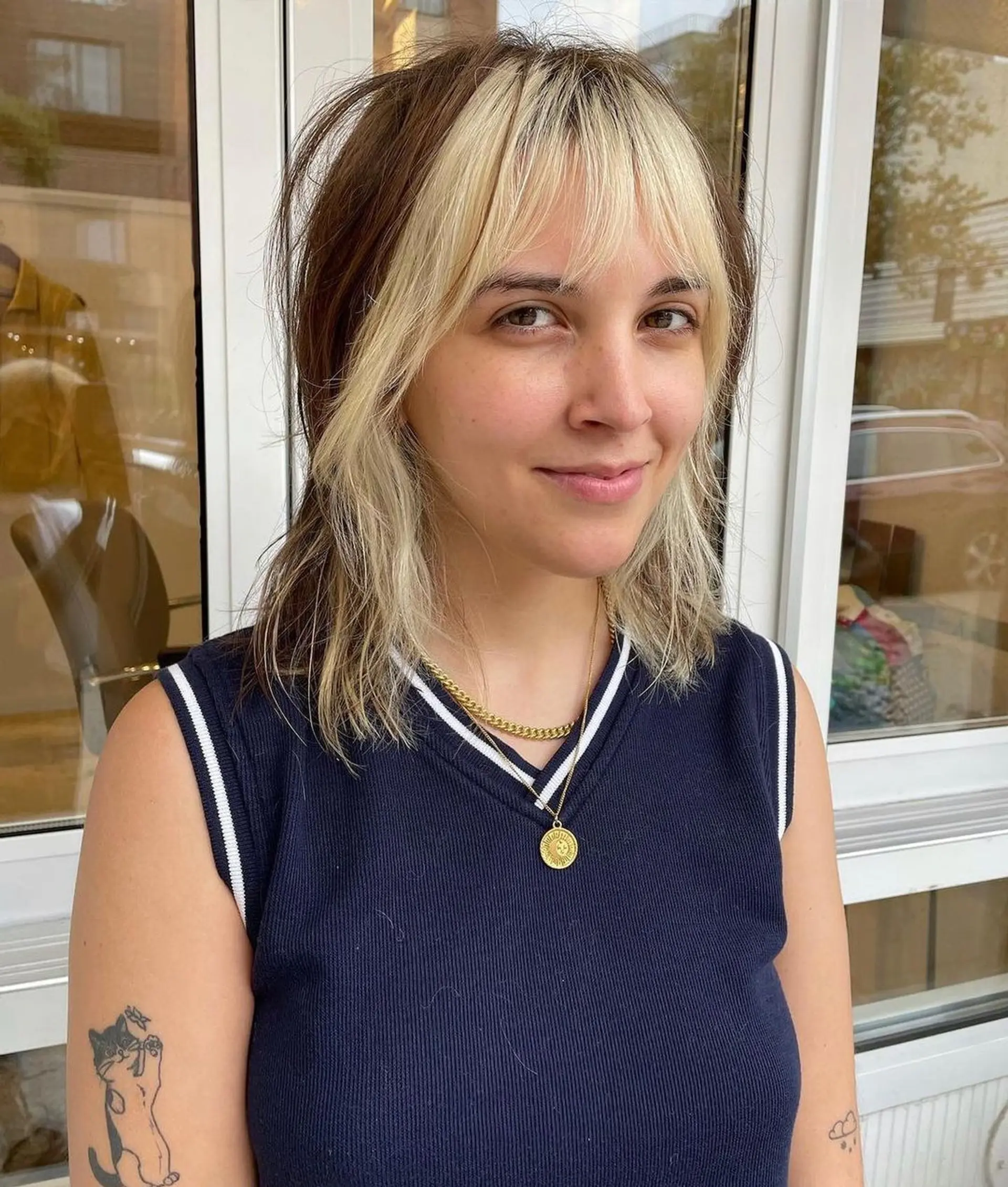 Medium-length wavy hair with shaggy layers, face-framing bangs, and high contrast blonde and brown highlights. 1