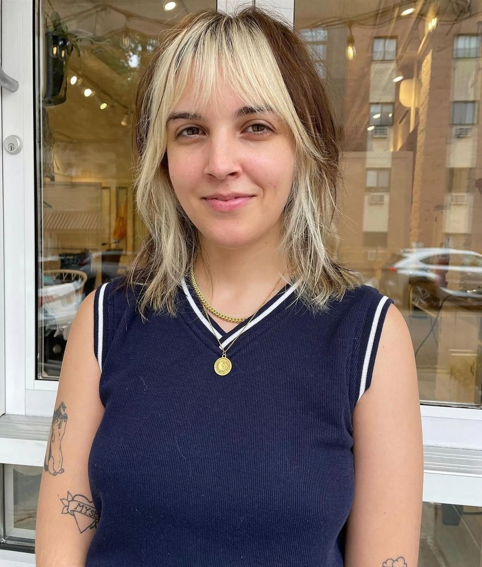 Medium-length wavy hair with shaggy layers, face-framing bangs, and high contrast blonde and brown highlights. 2