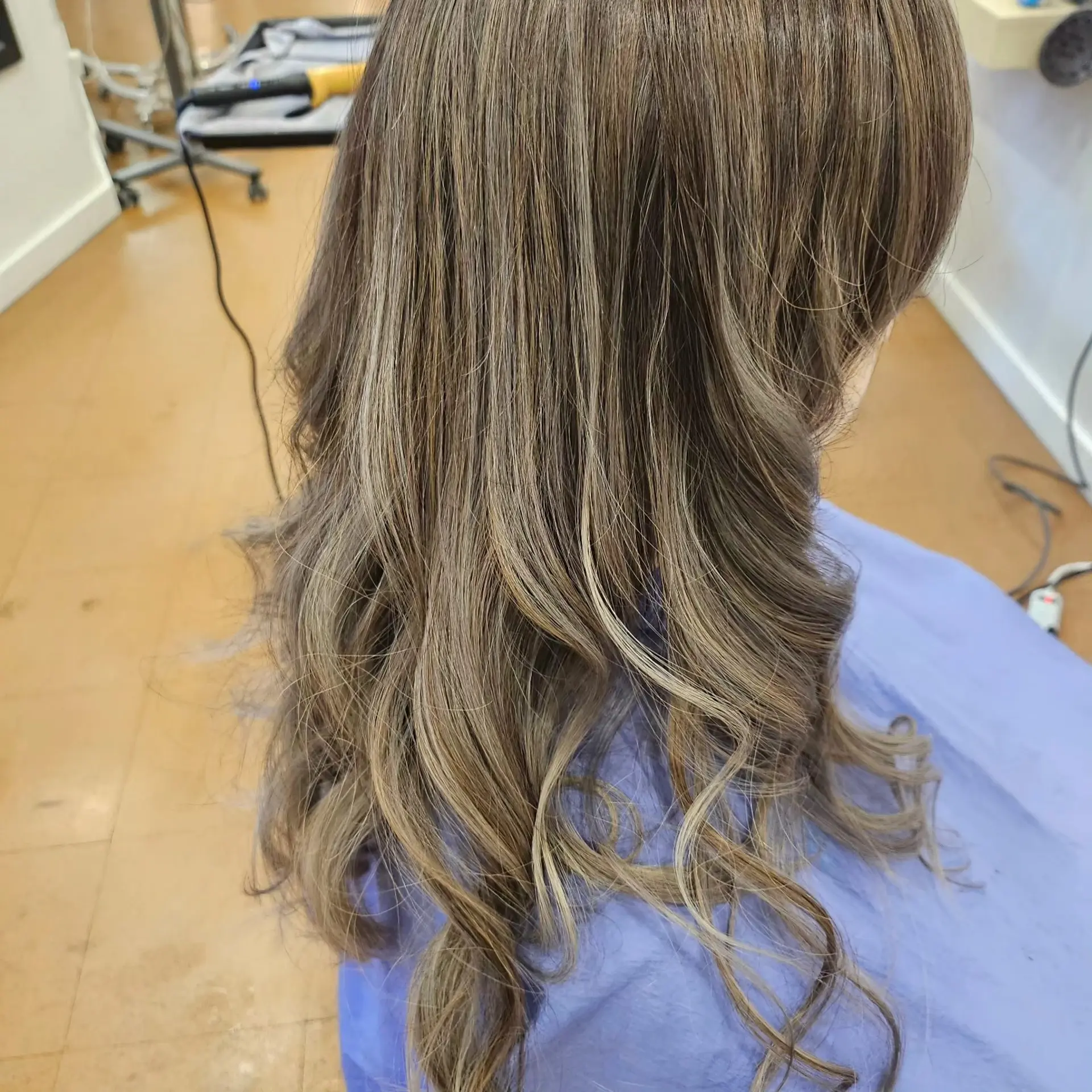 Long cool-toned brown hair enhanced with blended ash blonde balayage highlights and styled with loose curls at the ends. 1