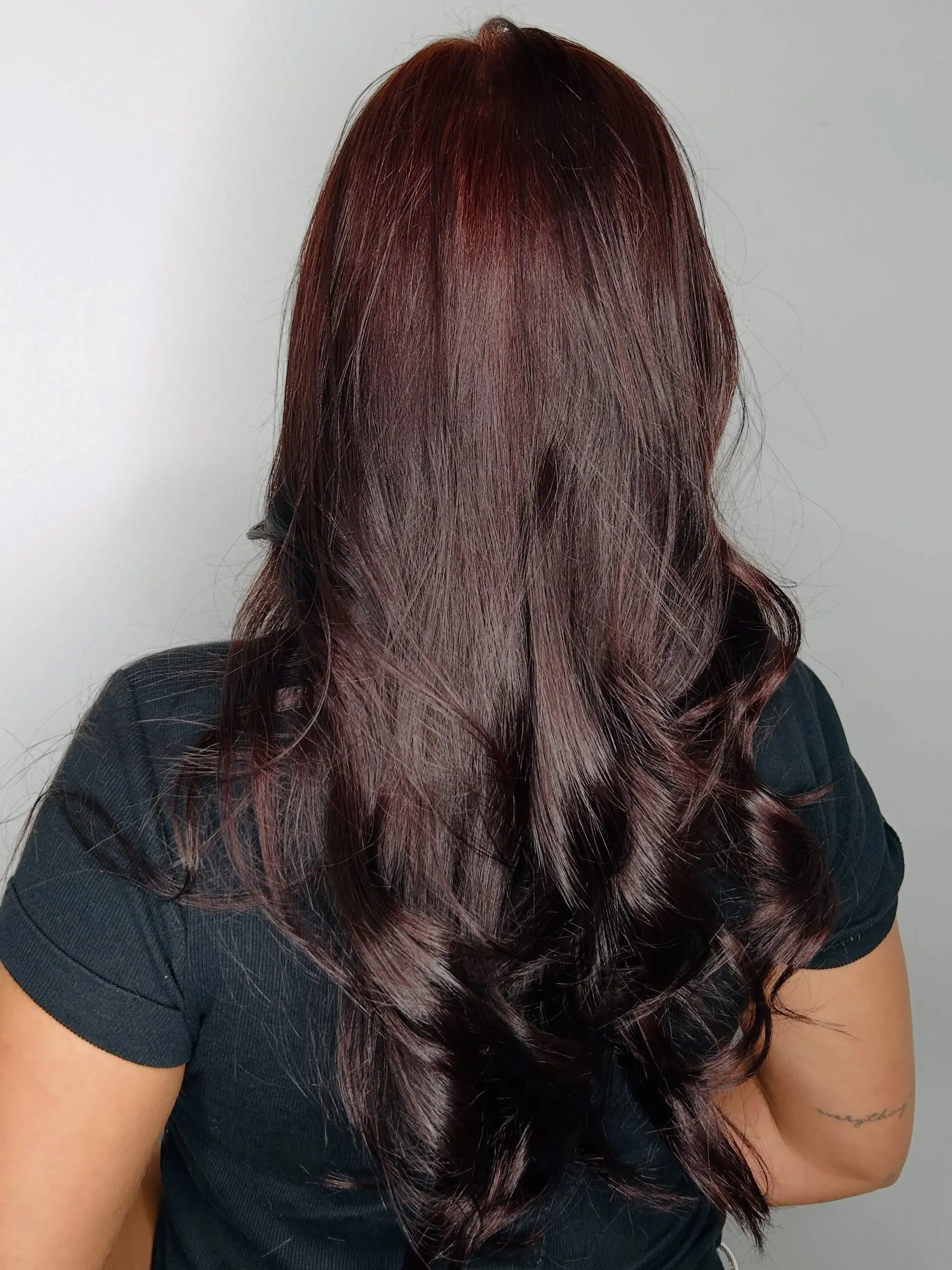 Long, glossy deep auburn-brown hair featuring smooth roots and soft, voluminous curls through the ends. 1
