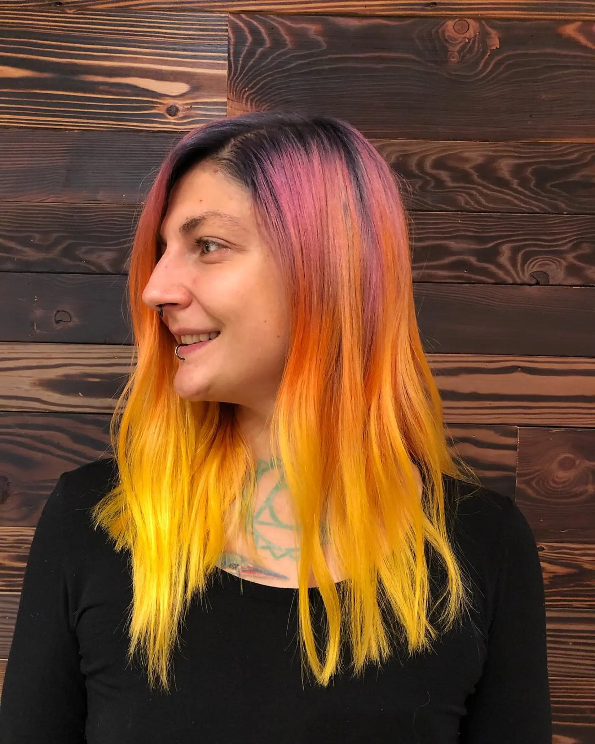 A vibrant sunset ombre with dark roots transitioning into pink, orange, and yellow ends. 1
