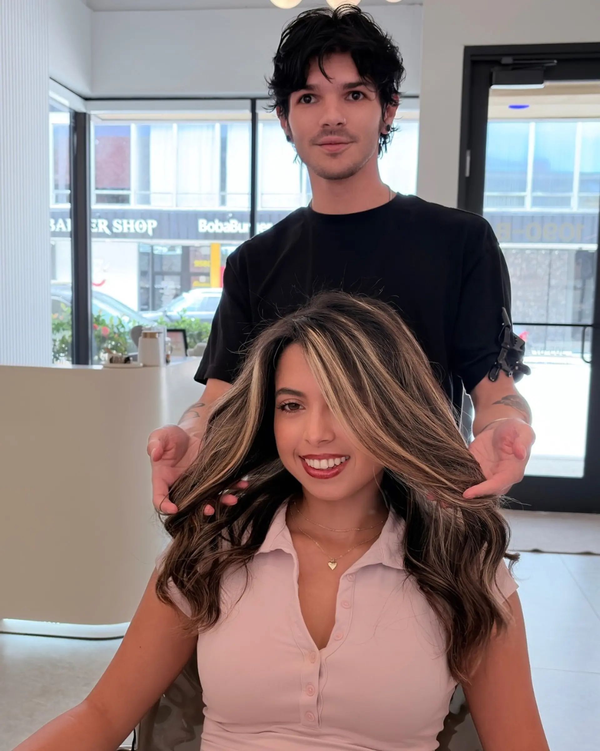 Long wavy brunette hair enhanced with bright blonde face-framing highlights and dimensional balayage. 1