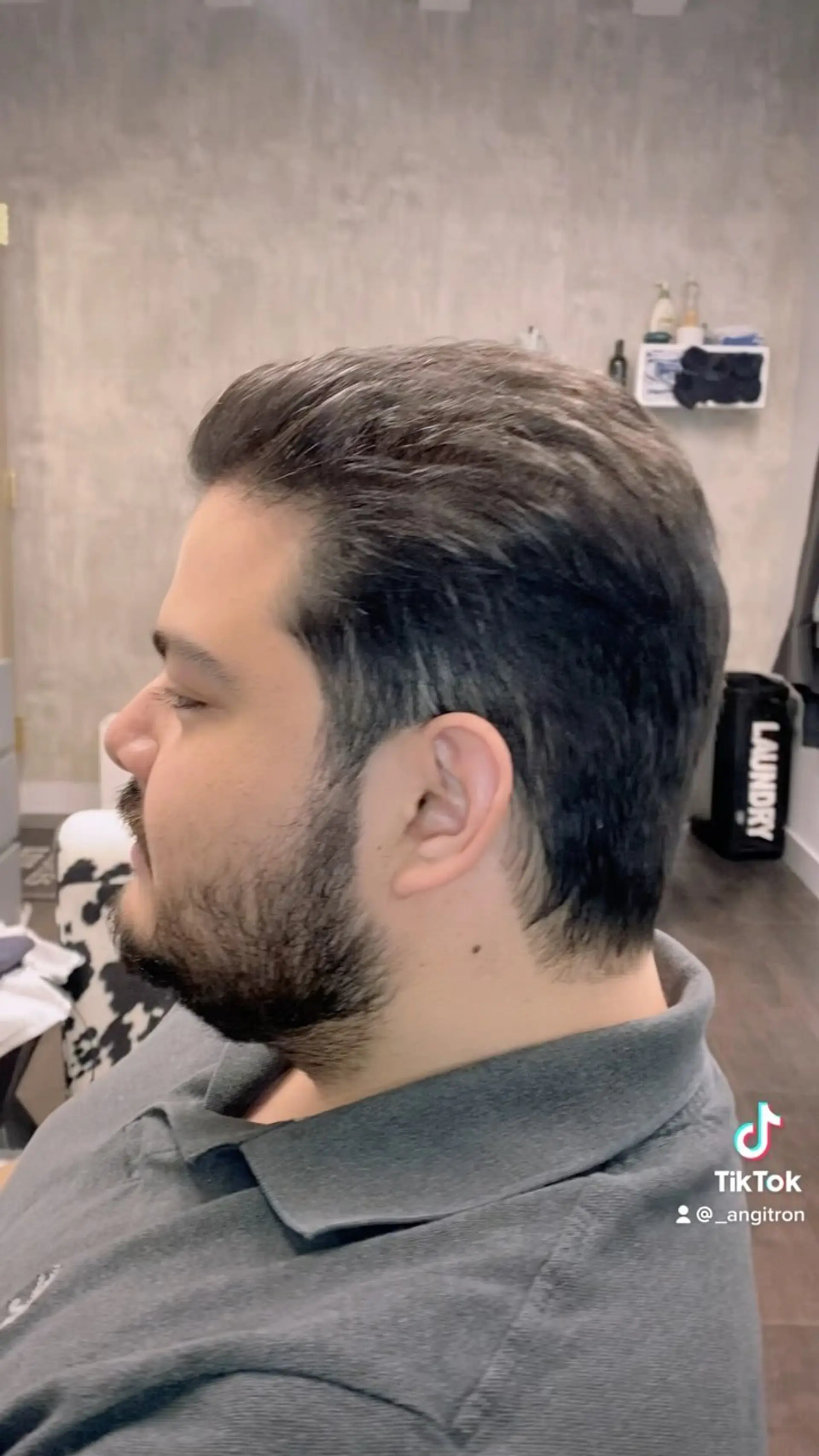 A tapered men's haircut styled smoothly back with soft layering and a natural neckline. 1