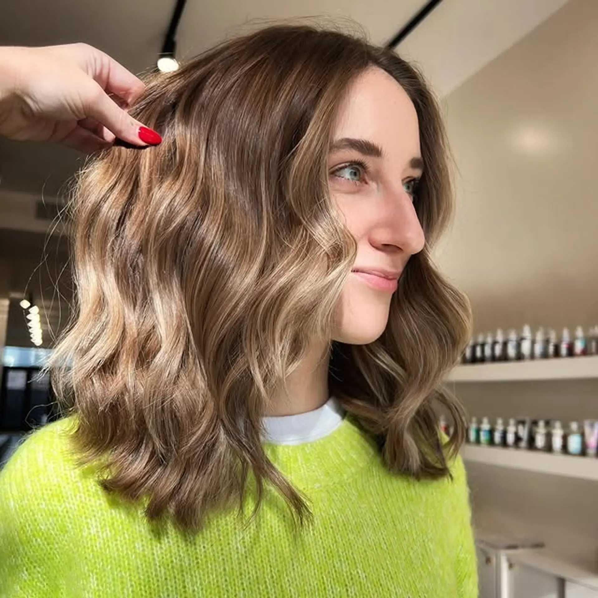 A Bronde Beach Waves Lob with soft, loose waves and face-framing highlights. 1