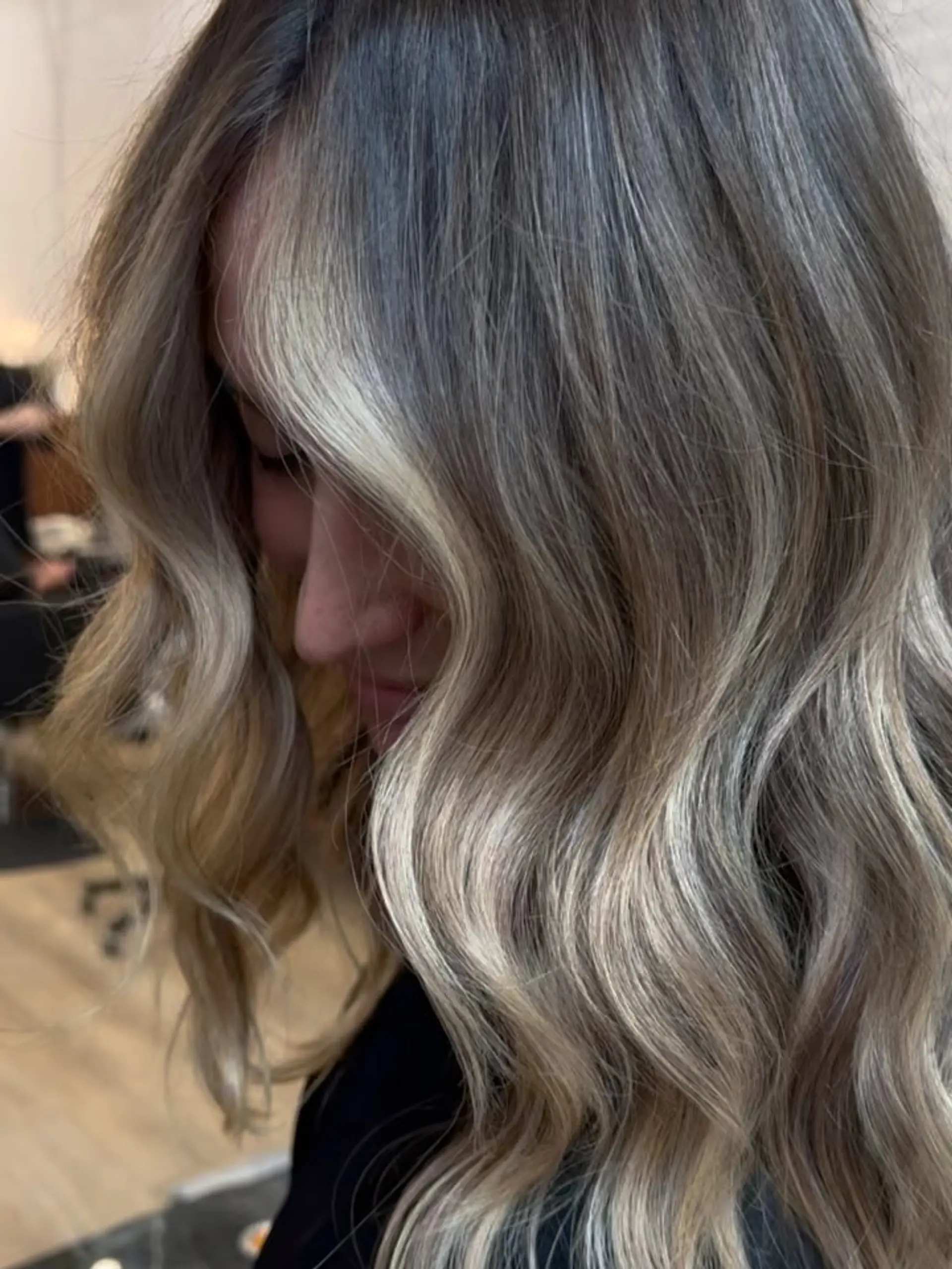 Medium-length dimensional ash blonde balayage with bright face-framing highlights styled in soft, cascading waves. 1