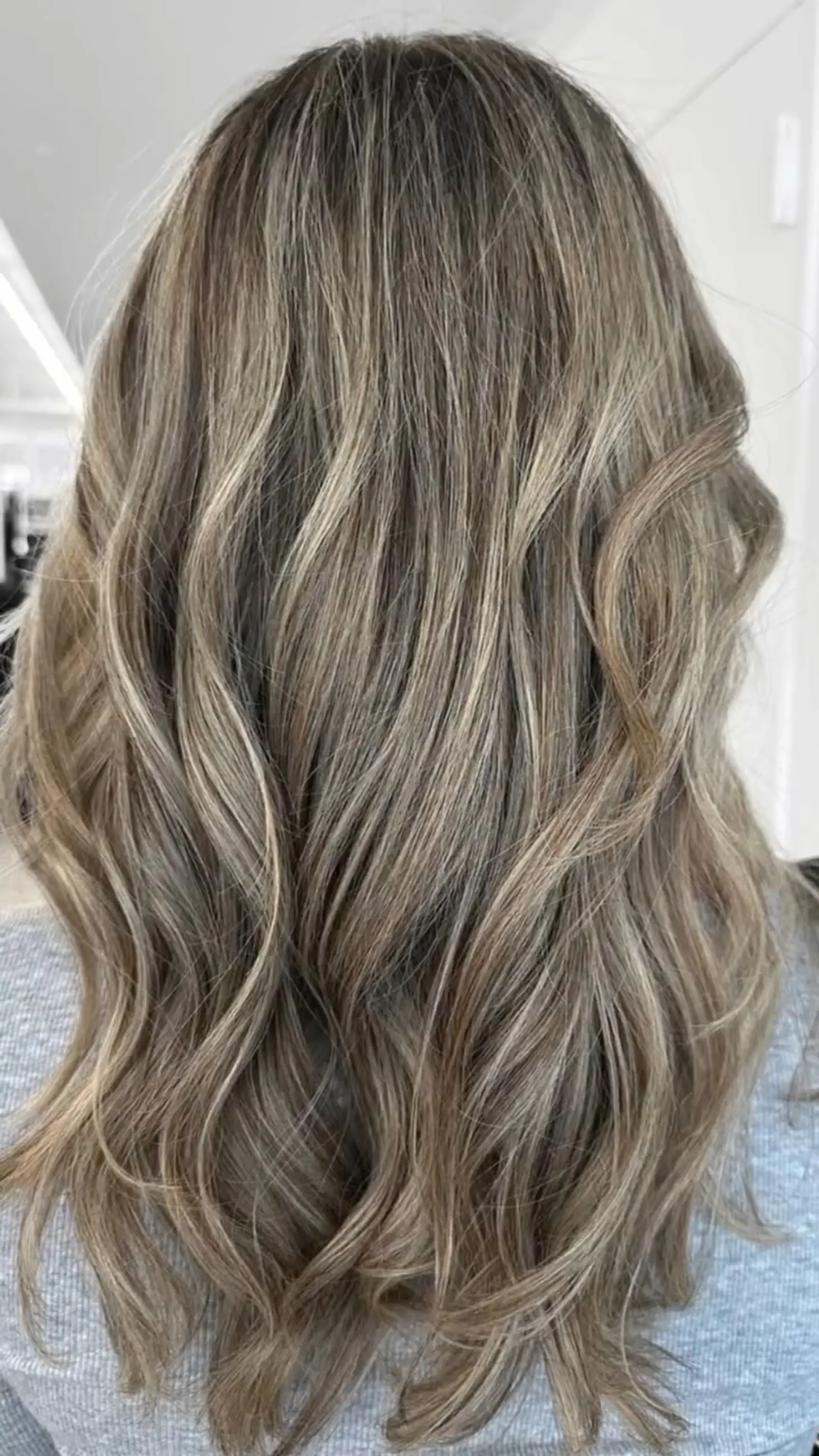 Long light brown hair detailed with subtle ash blonde highlights and loose waves. 1
