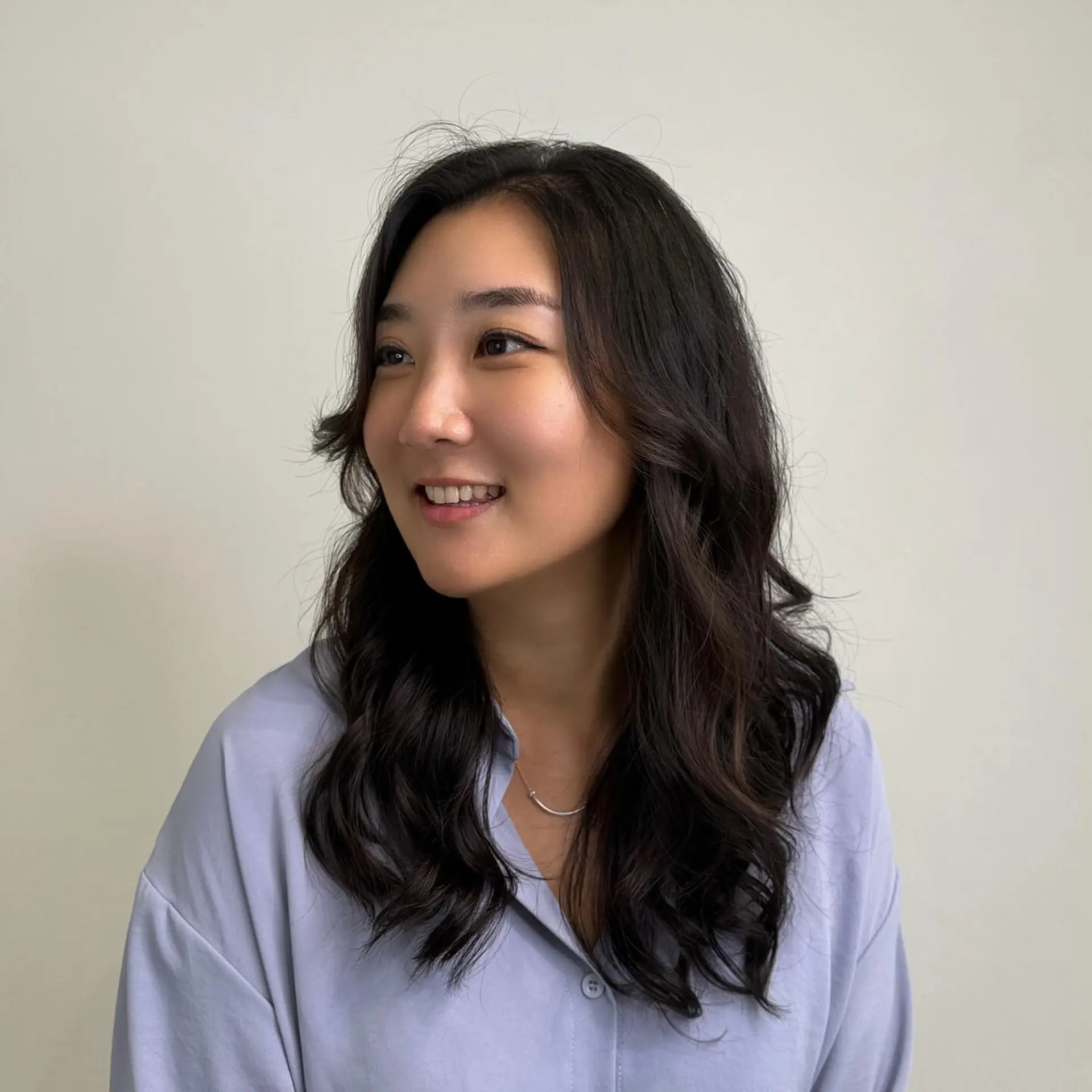 Long dark hair styled into soft, natural digital waves with subtle face-framing layers. 1