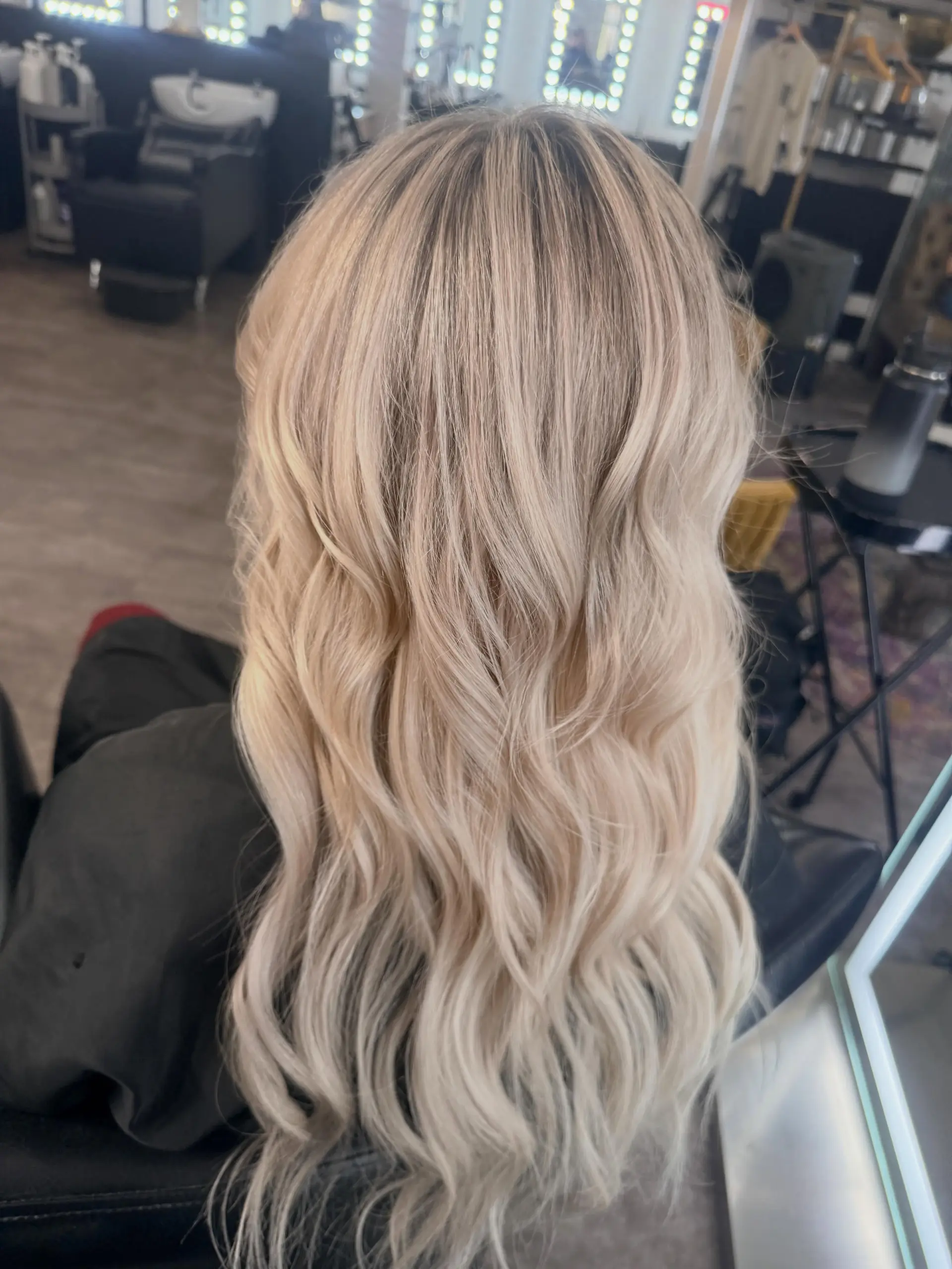 Long, luminous blonde hair styled in effortless, cascading loose waves with seamlessly blended weft extensions. 1